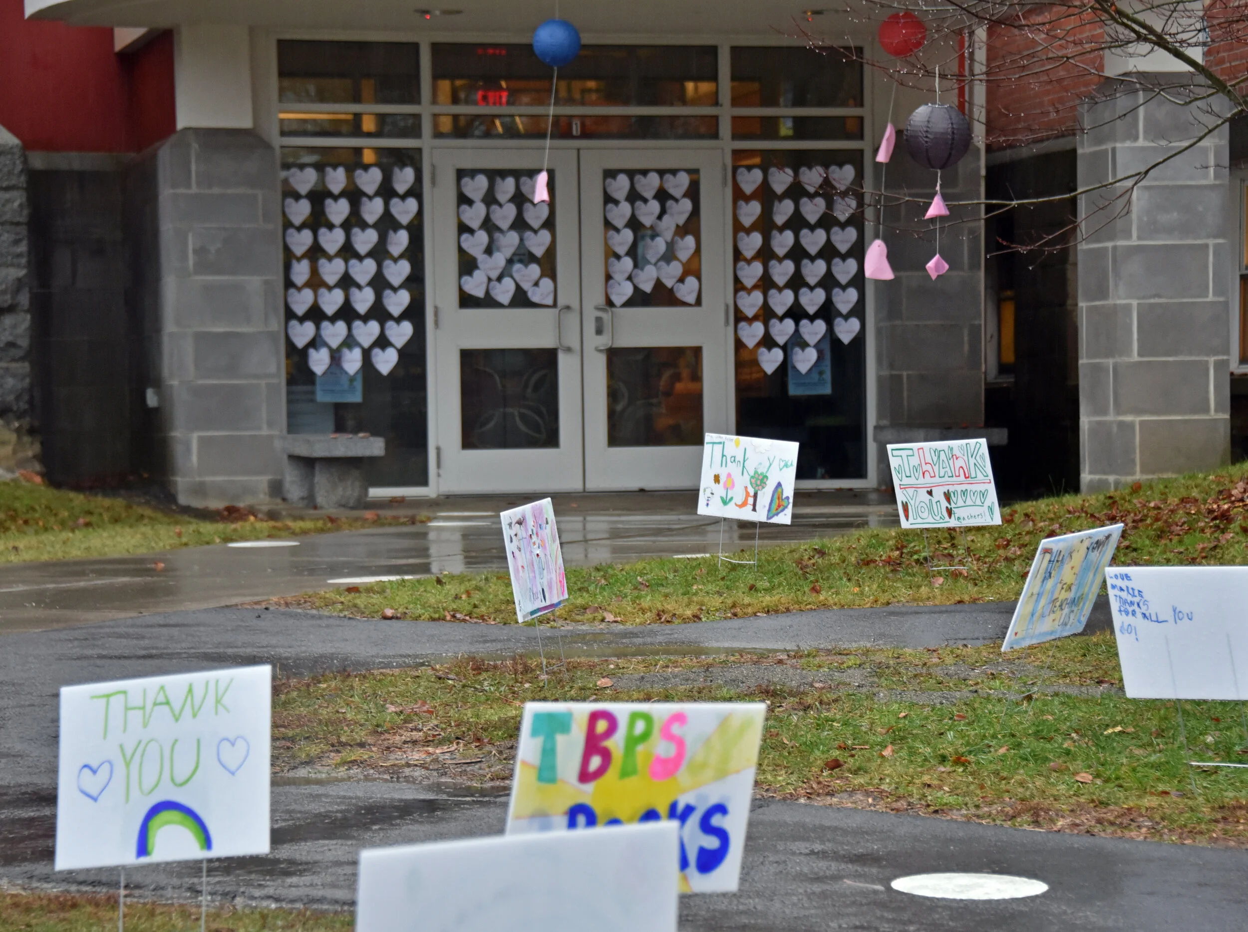  Dozens of signs were planted around the school entrances. More than 80 hearts with names of teachers and staff were taped to the main entry doors. Photo by Gordon Miller.  