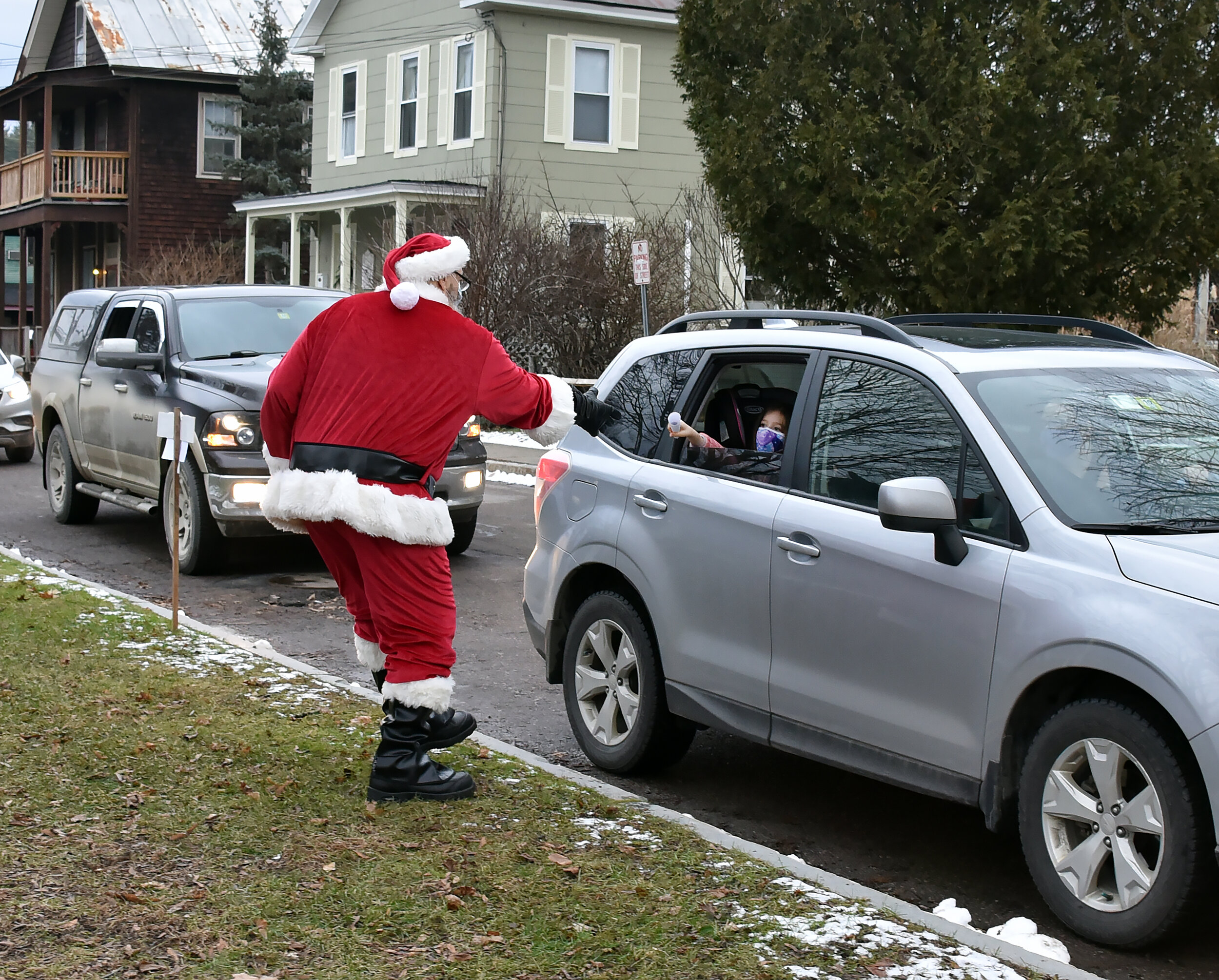   Santa accepts a rolled-up list from a backseat tot. Photo by Gordon Miller.  