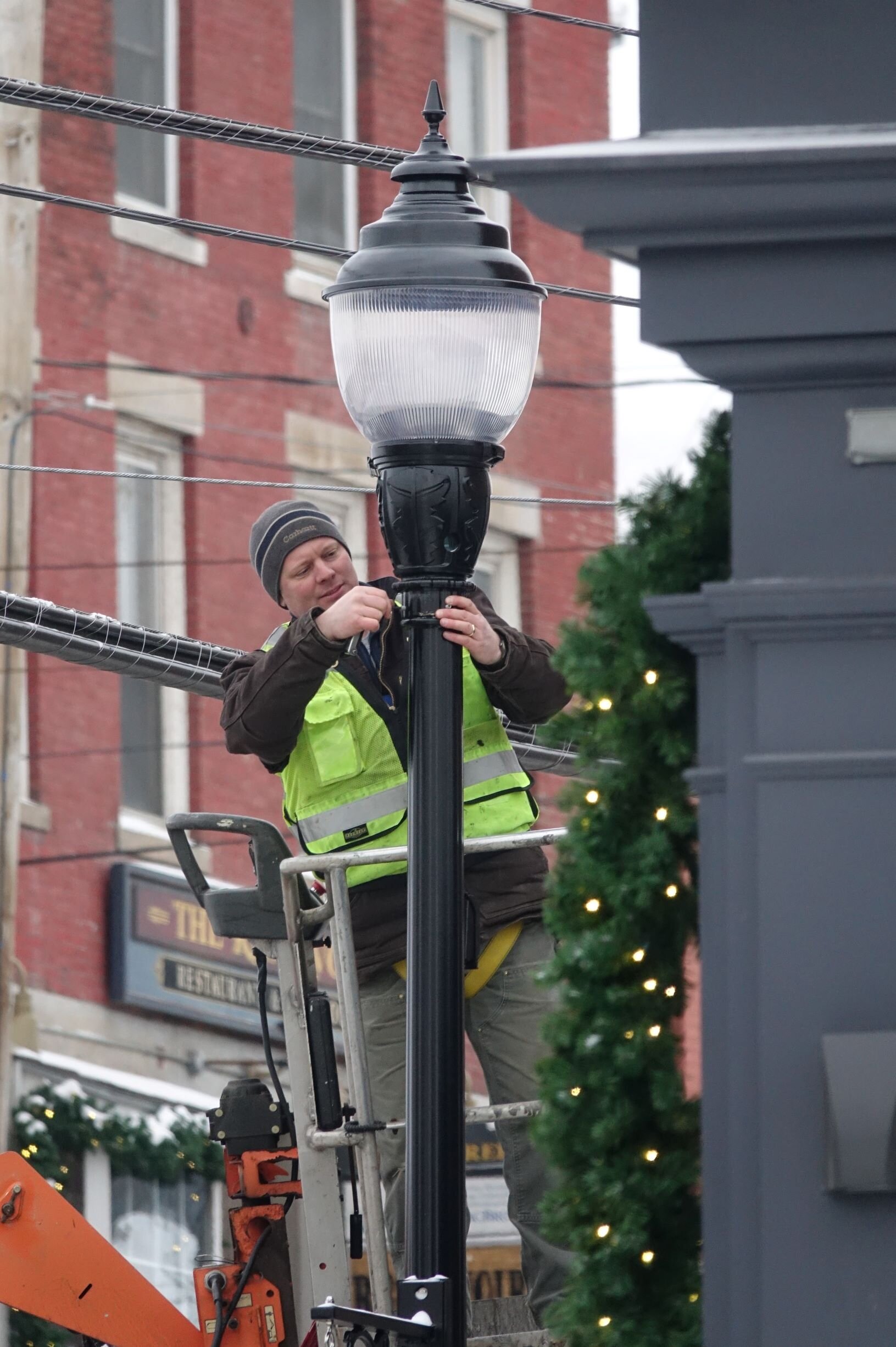   Last one out, put up the lights. Contractors continue working on street lights and signals as the Main Street reconstruction project wraps up for the winter. Photo by Gordon Miller.   
