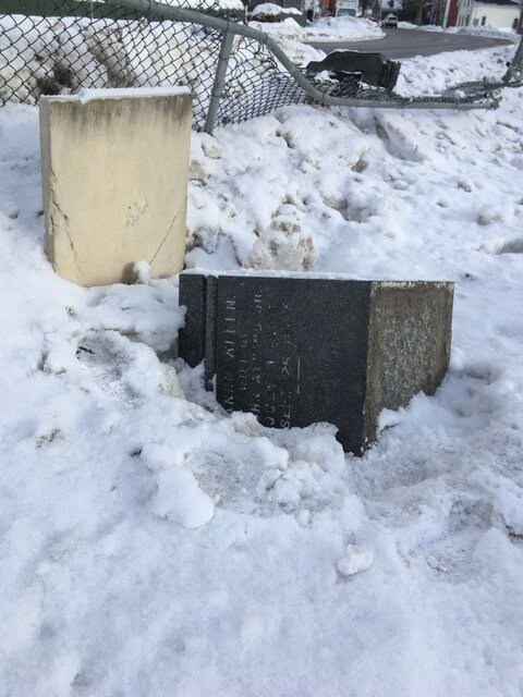 A large headstone rests on its side. Photo by Jill Chase.