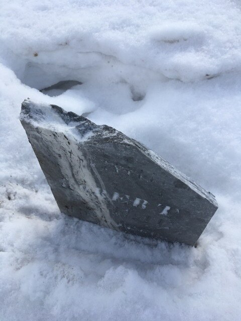 Detail shows a damaged gravestone. Photo by Jill Chase.