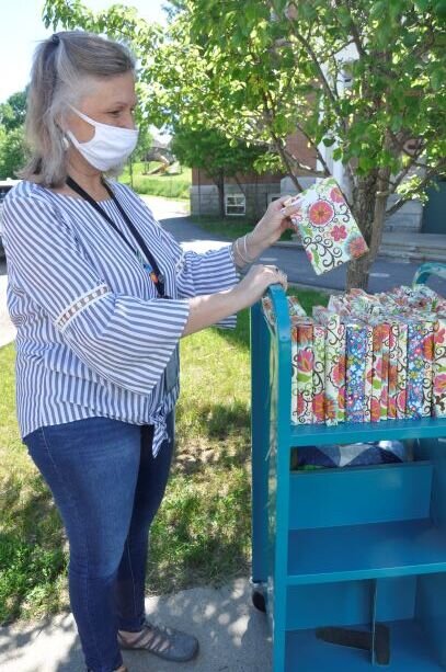  Librarian Nancy Daigle has a colorful assortment of wrapped books on her cart to hand out as graduation gifts.  Photo by Lisa Scagliotti 