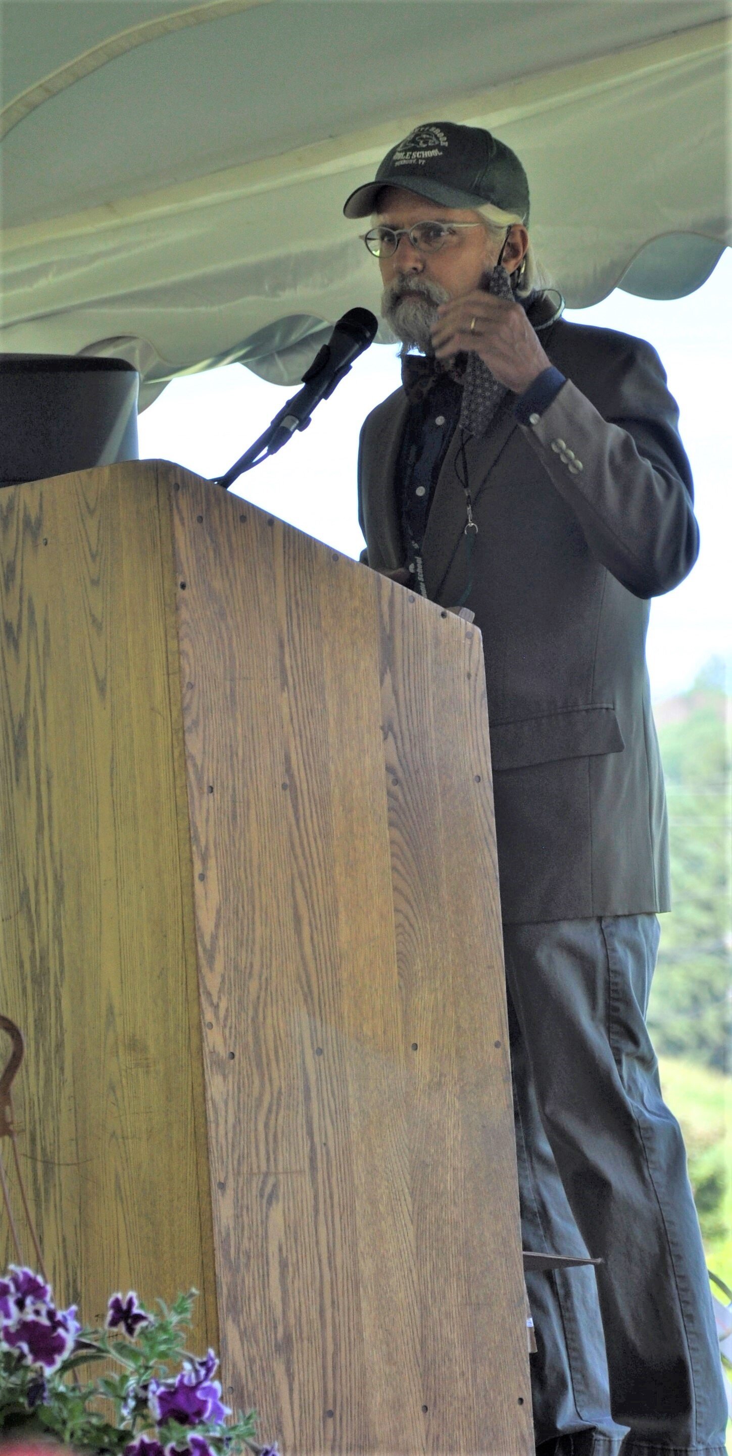   Principal Tom Drake removes his mask to begin the ceremony. Photo by Bill Brundage.  