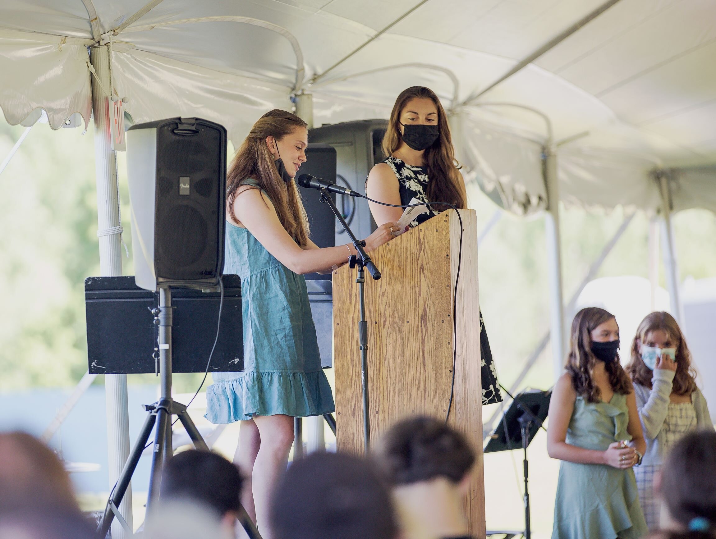   8th graders Eloise Lilley and Addison Thomas deliver remarks in the program. Classmates Ava Reagan and Sadie Benson (right) look on. Photo by Michaela Milligan.  