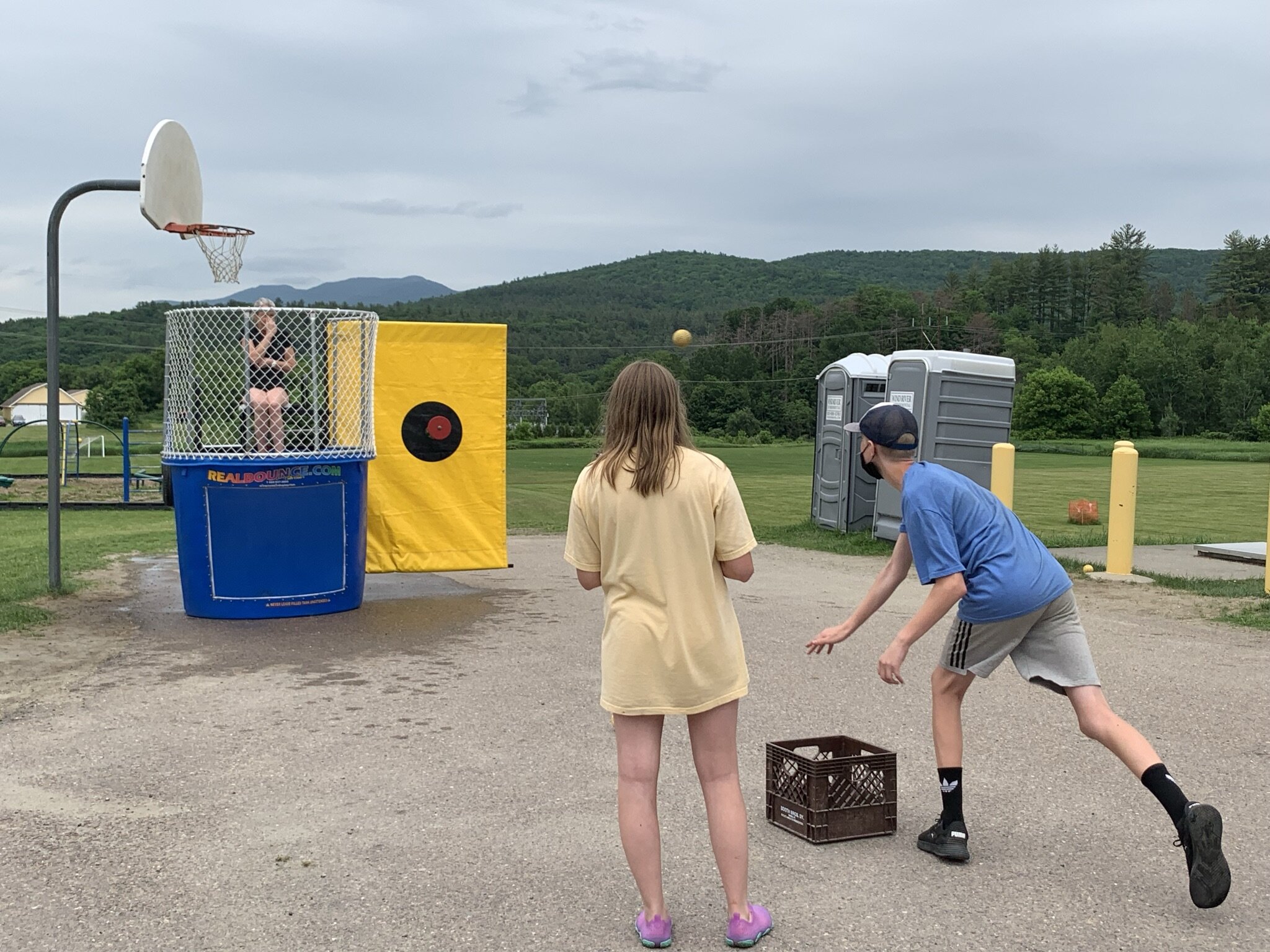 Students take turns tossing balls to trigger the dunk tank at 8th Grade Fun Night for a chance to soak teachers. Good-sport candidates included teacher Victoria Smith (pictured), Assistant Principal Josh Estes, and teacher Eric Eley. Photo by Lisa S