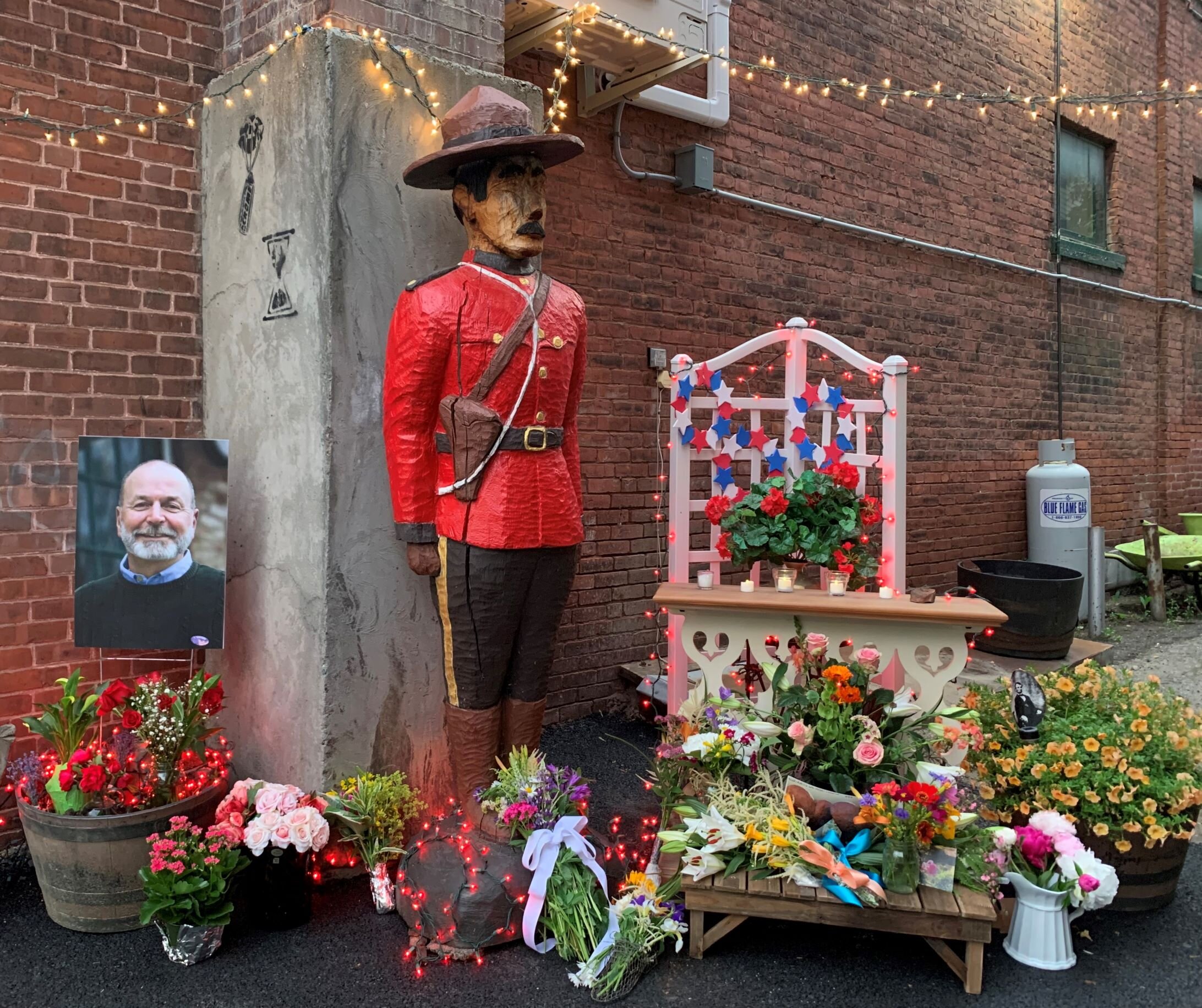  A colorful memorial comes together in the alley beside Stowe Street Emporium as news of Jack Carter's passing spreads through the community on Tuesday, June 22. The wooden Canadian Mountie was a familiar fixture in the shop when Carter and Schulthe