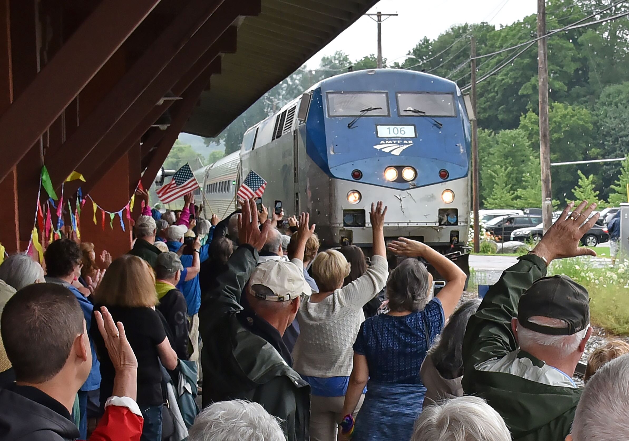   The crowd cheers and waves from the platform at the Waterbury Train Station Monday morning as Amtrak's Vermonter pulls in for its first stop in over a year as passenger train service in Vermont resumes. Photo by Gordon Miller  