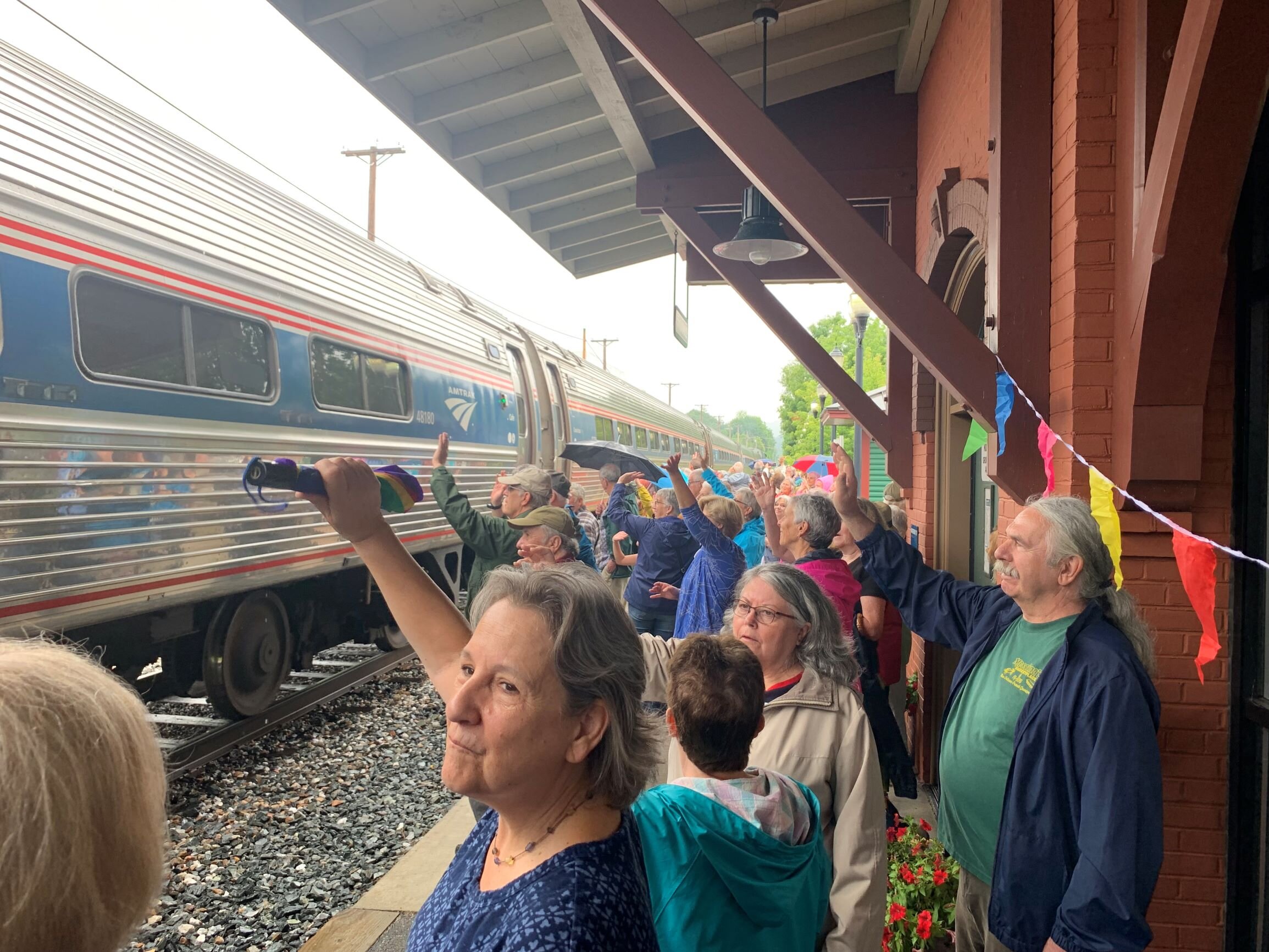   Local residents wave farewell as the train lumbers off to its next stop: Montpelier Junction. Photo by Lisa Scagliotti  