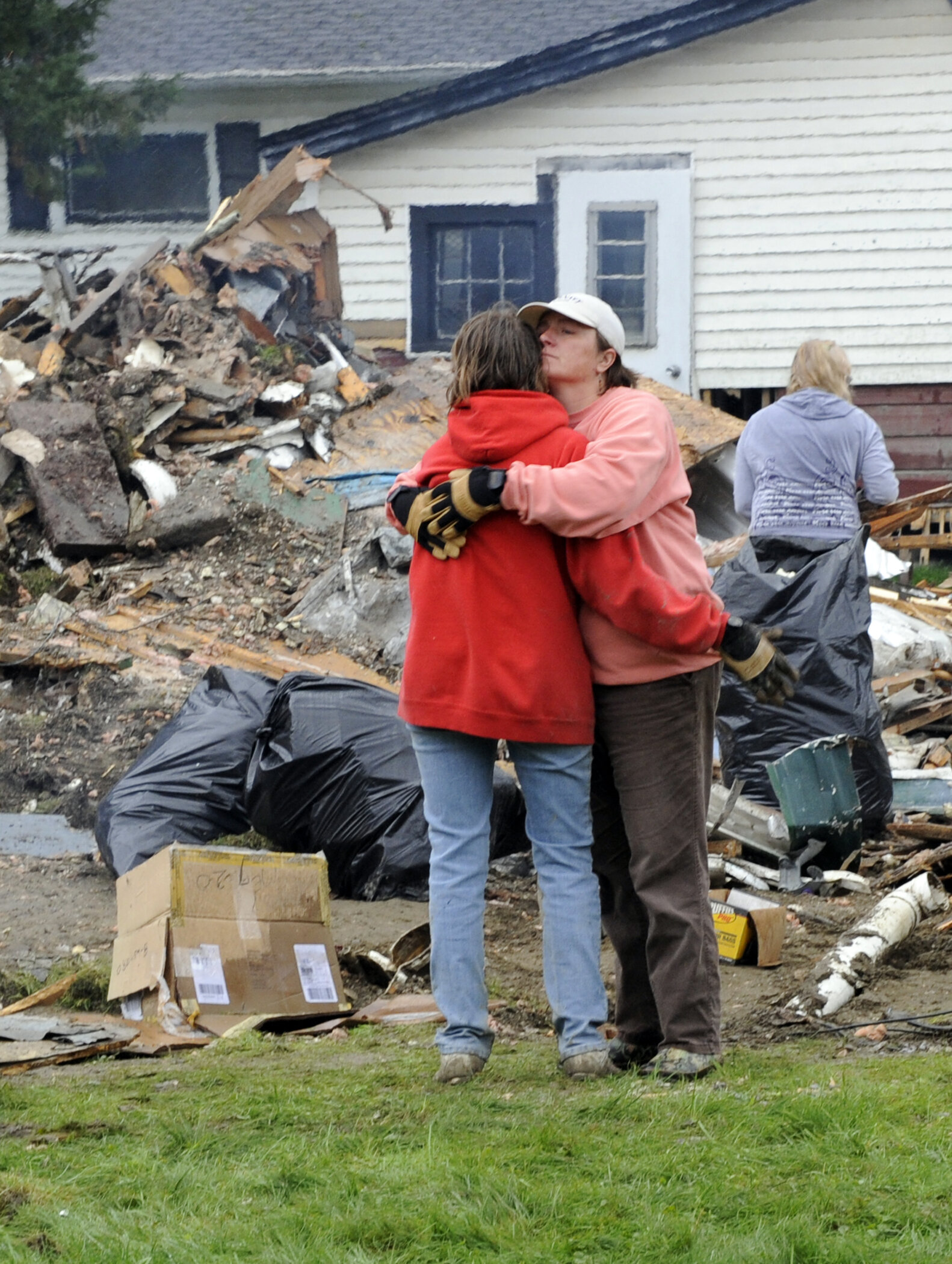  Family members Teresa Haskins and mother Sue Levine take a moment during exhausting cleanup. Photo by Gordon Miller 