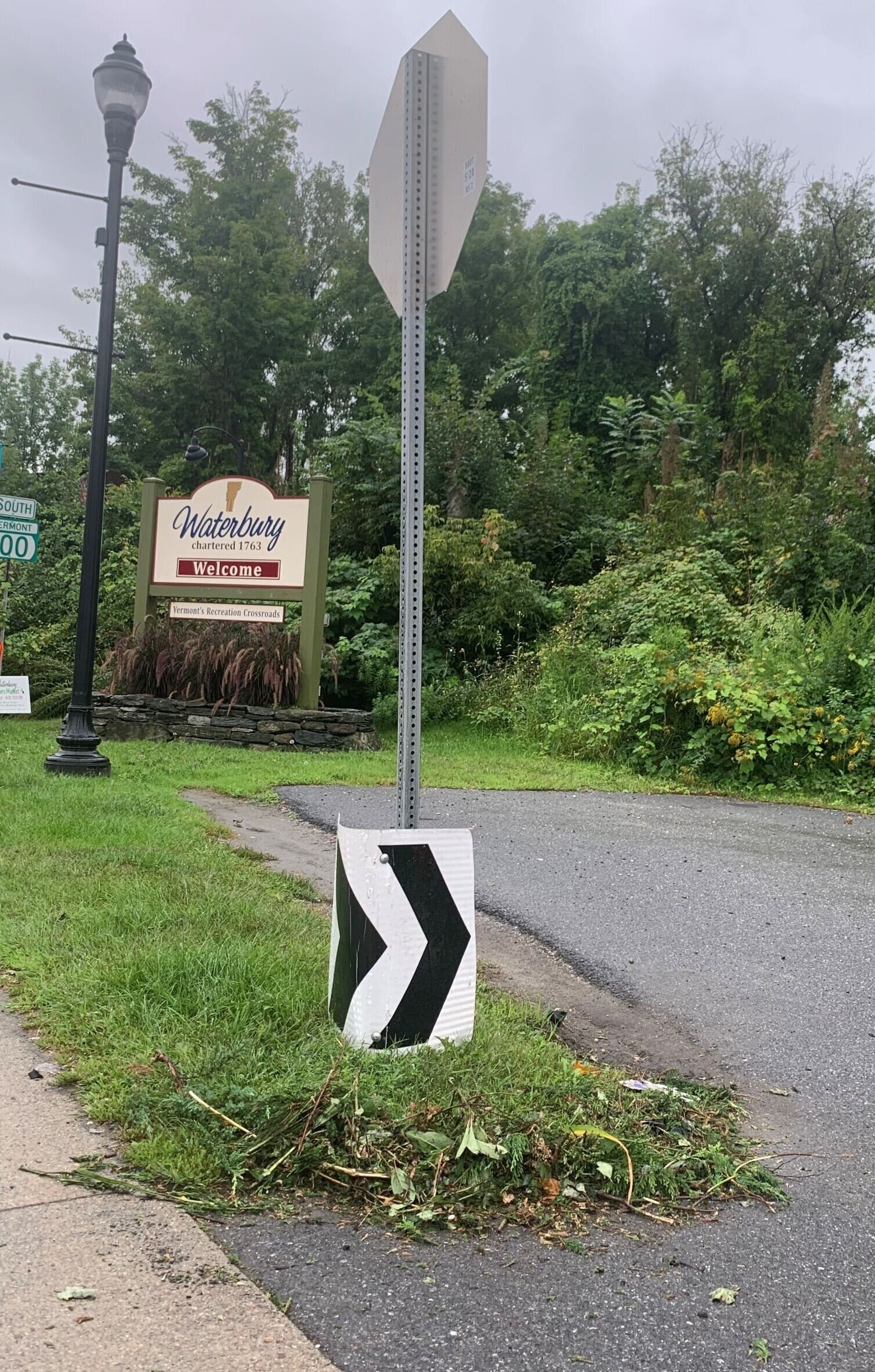 A chevron directional sign previously mounted on a pole in the roundabout sits beside a stop sign across Main Street after the crash. Photo by Lisa Scagliotti