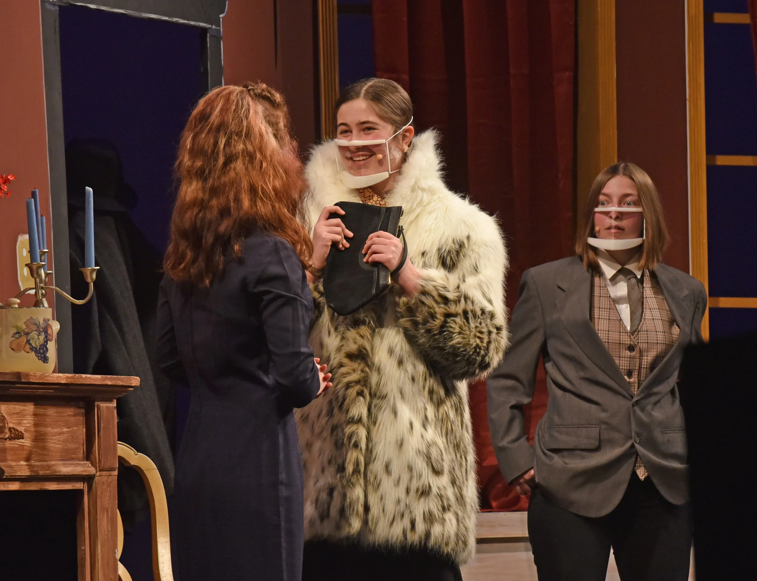   Clear masks are fitted with microphones to help with sound quality during the show. Mr. Paravincini (played by Lucie Ruggiero) enters a scene. Photo by Gordon Miller.  