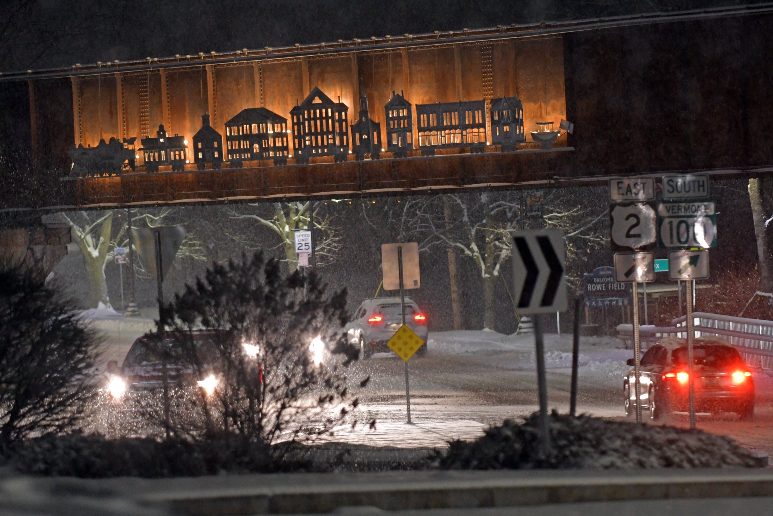  The gateway to town glows in the light of traffic and the railroad bridge sculpture in the snow. Photo by Gordon Miller  