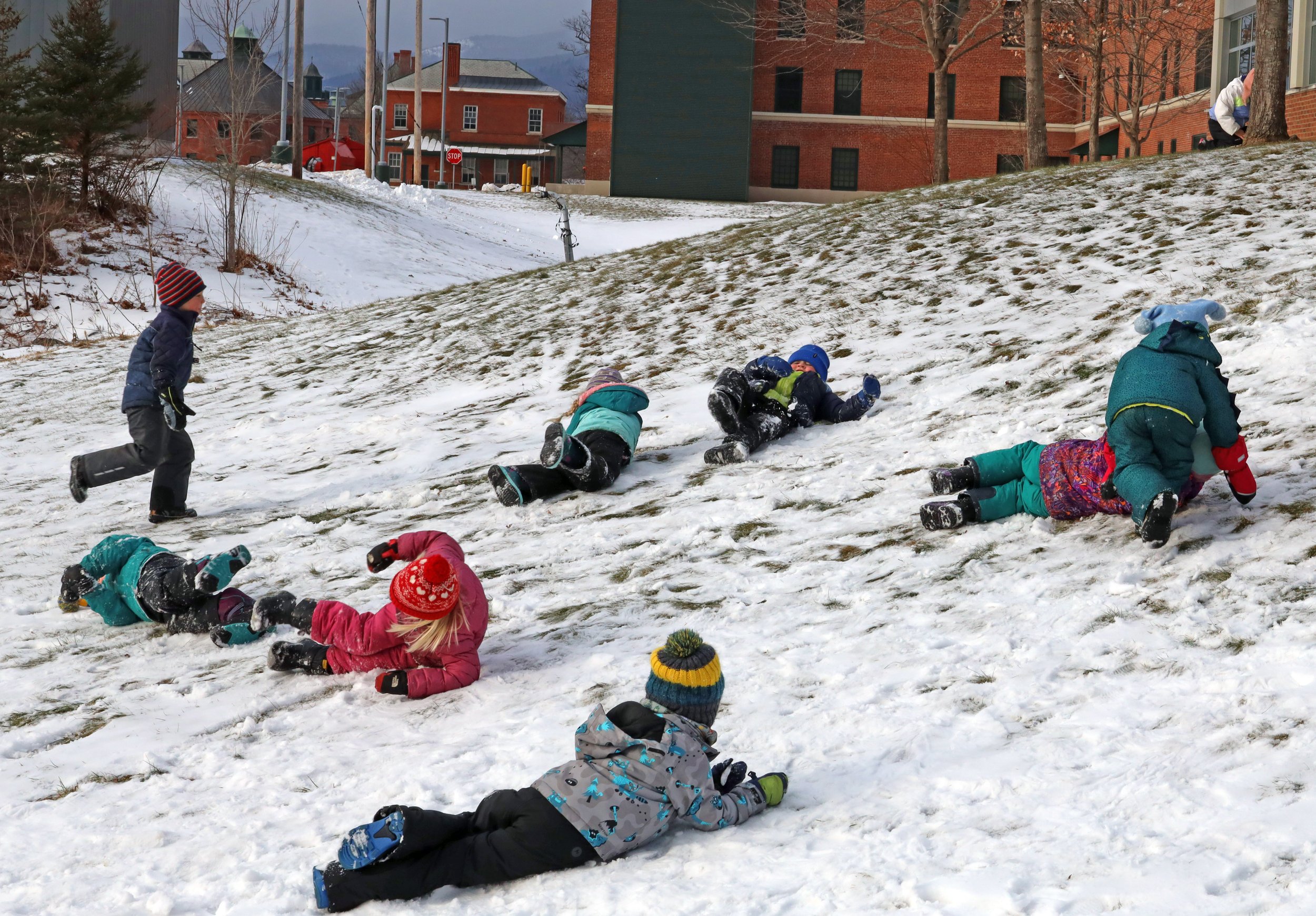  Scant snow is not a problem for these preschoolers at Hunger Mountain Children's Center who enjoy rolling at the state office complex last week. Photo by Gordon Miller 