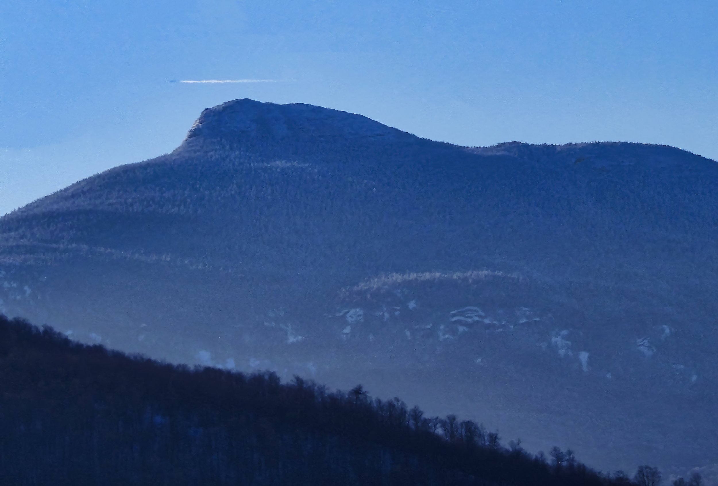   An optical illusion makes it look as if a jet just passes over Camel's Hump. Photo by Gordon Miller  