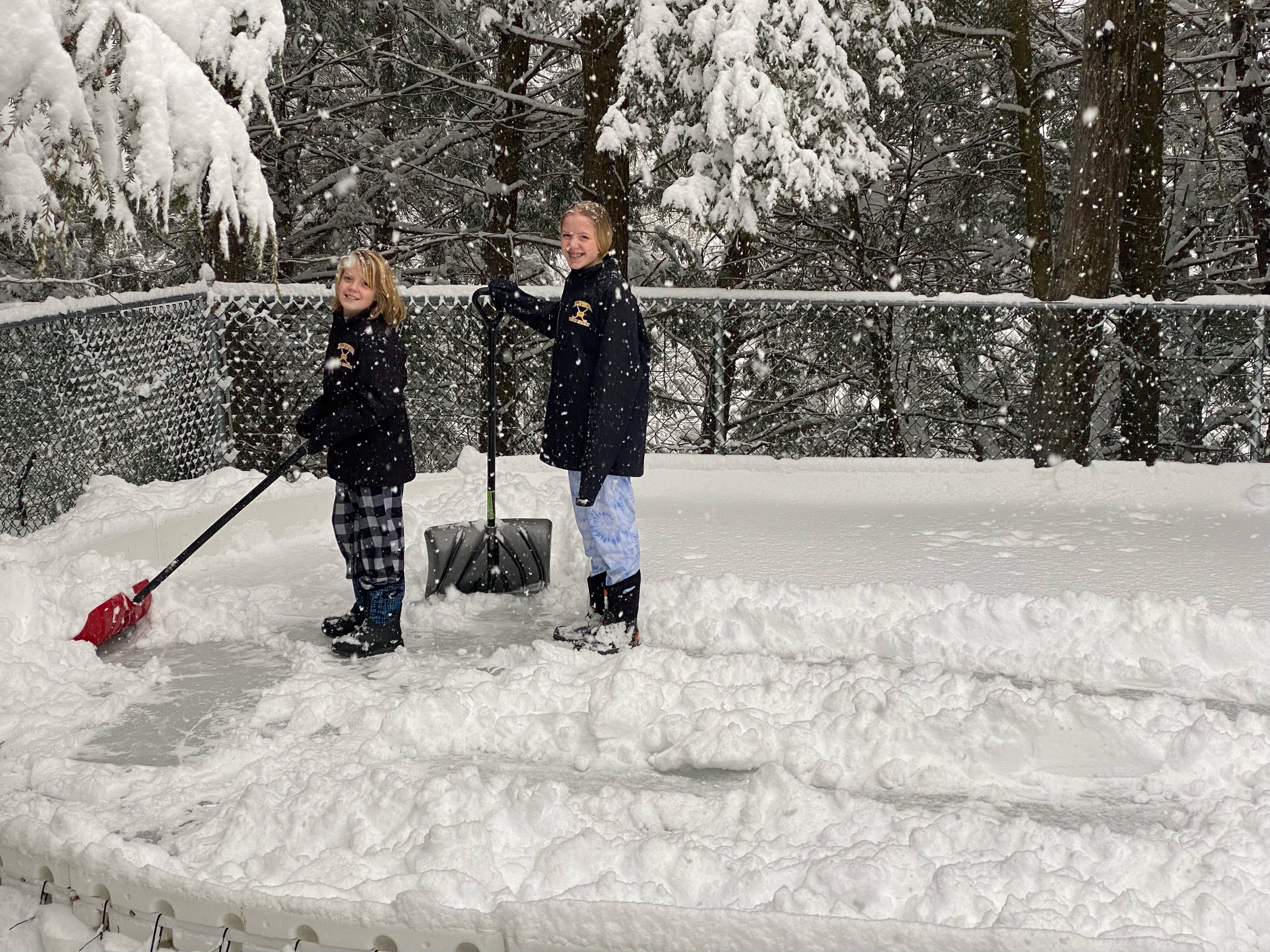   No zamboni? No problem. Trey and Alexandria Isham take on clearing their backyard rink in Duxbury. Photo by Amanda Isham  