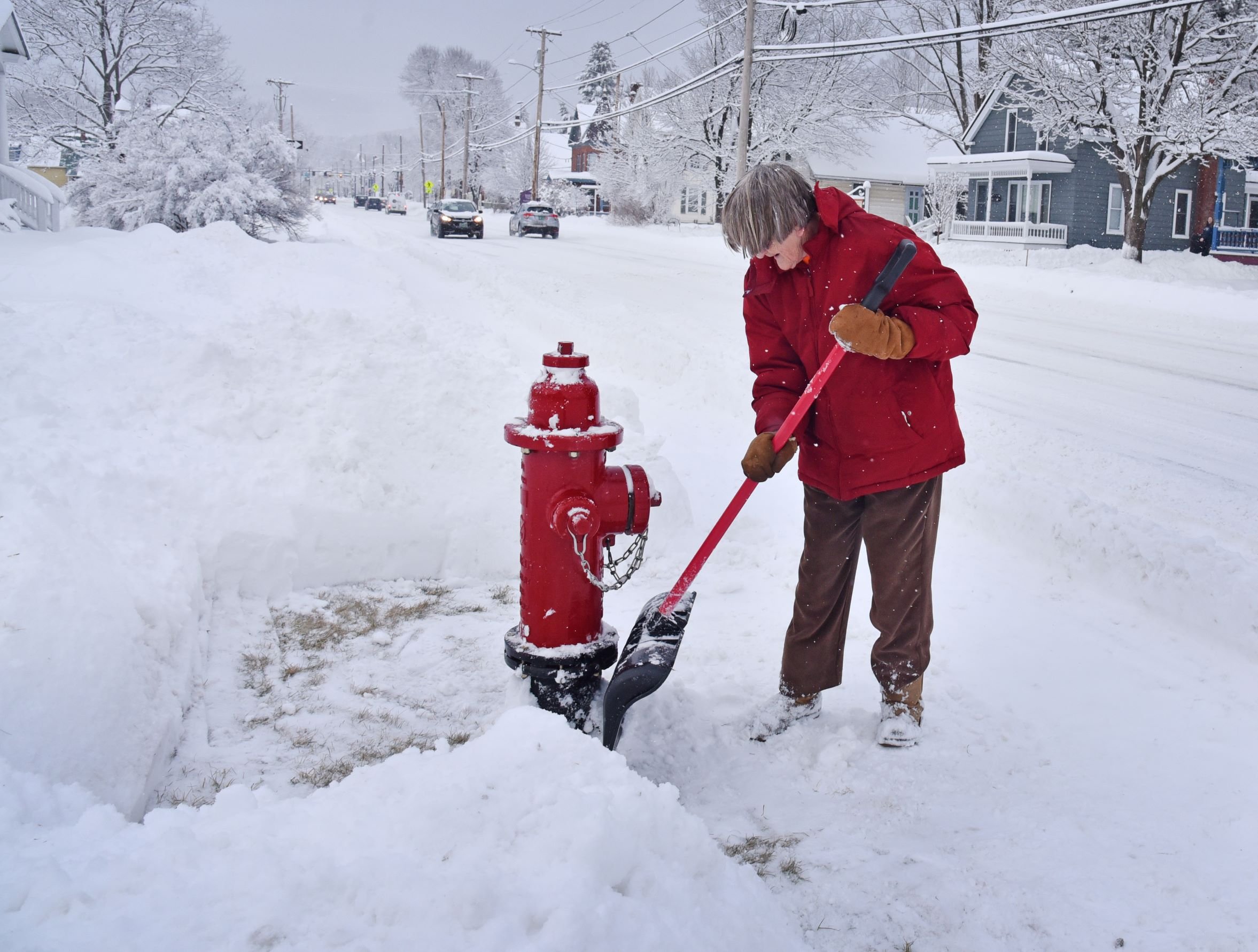  Shirley Boardman clears snow away from the fire hydrant on South Main Street near St. Andrew's Church. Photo by Gordon Miller 