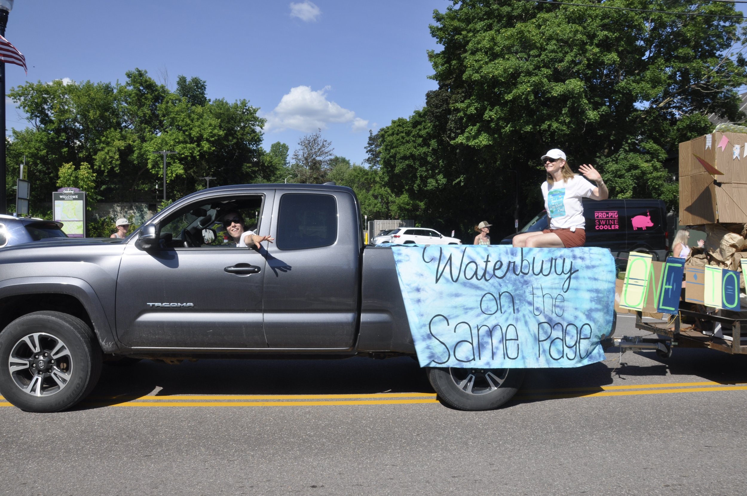  Bridgeside Books owner Katya d’Angelo pulls a float with author Catherine Drake whose book, “The Treehouse on Dog River Road” is part of a townwide book club this summer. Photo by Lisa Scagliotti 