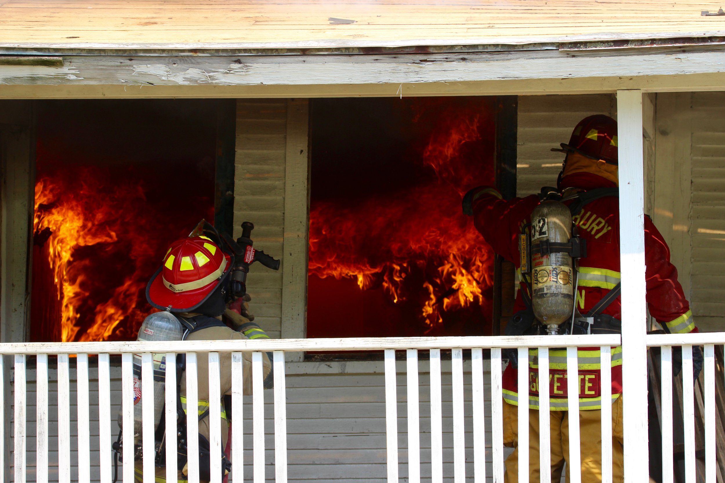   A Stowe firefighter and Captain Kyle Guyette on the porch. Photo by René Morse  