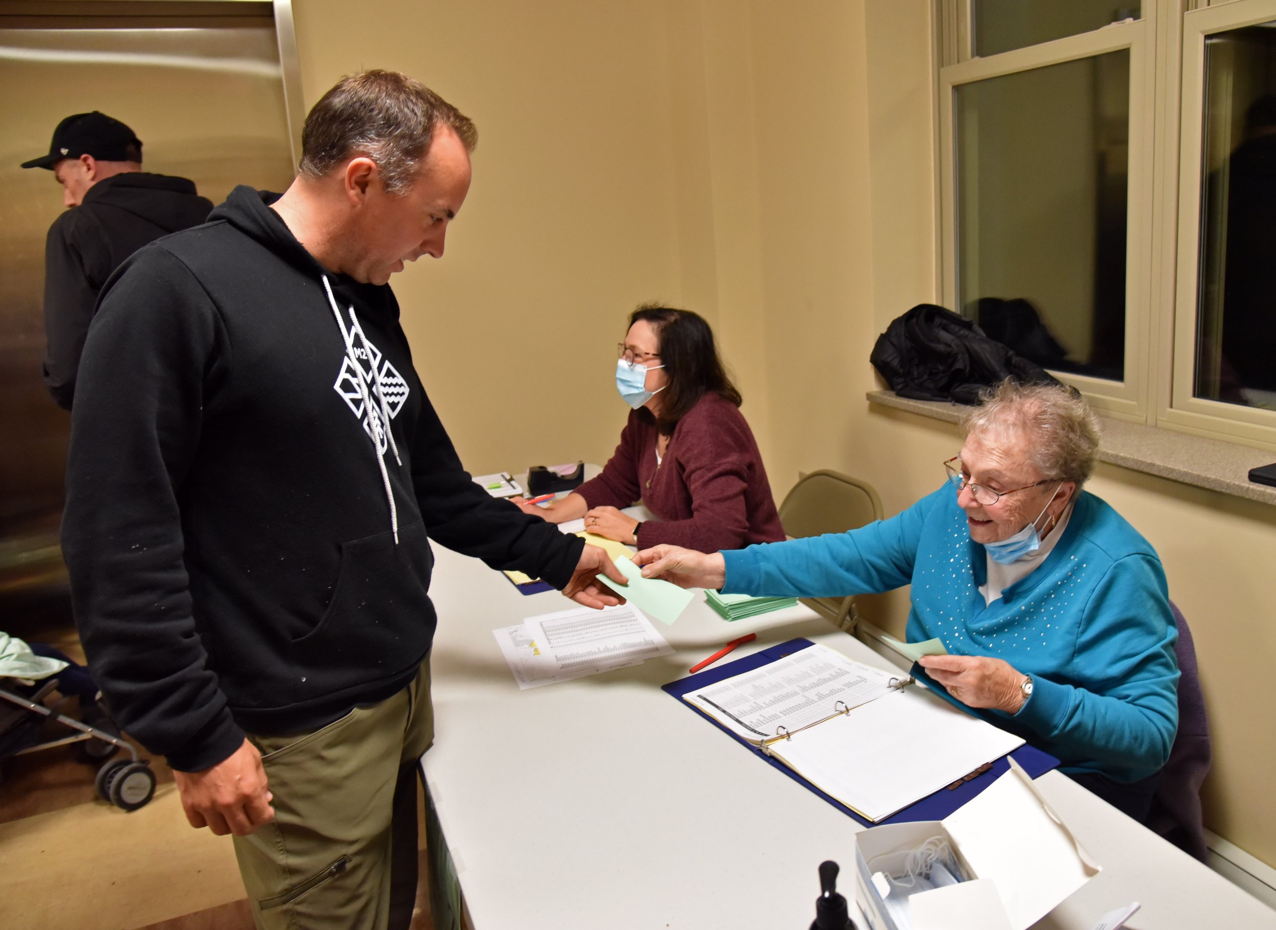   Members of the Board of Civil Authority checked voters names on the checklist and handed out simple paper ballots. Photo by Gordon Miller  