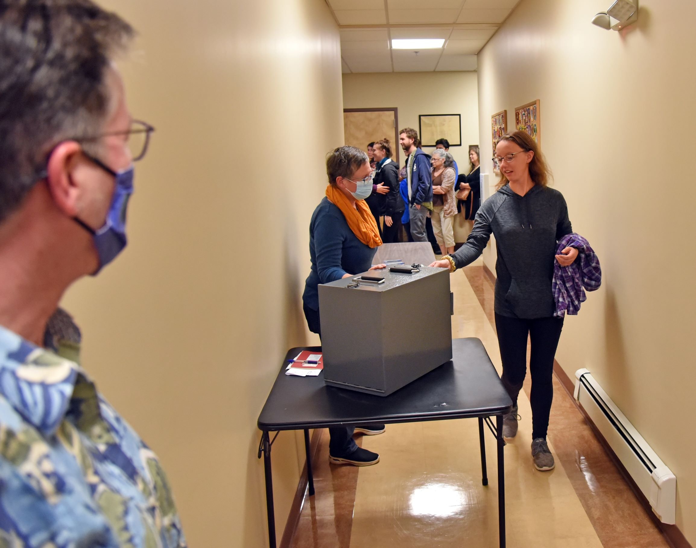  Board of Civil Authority Chair Liz Schlegel watches the ballot box as voters drop in their paper ballots. Photo by Gordon Miller 