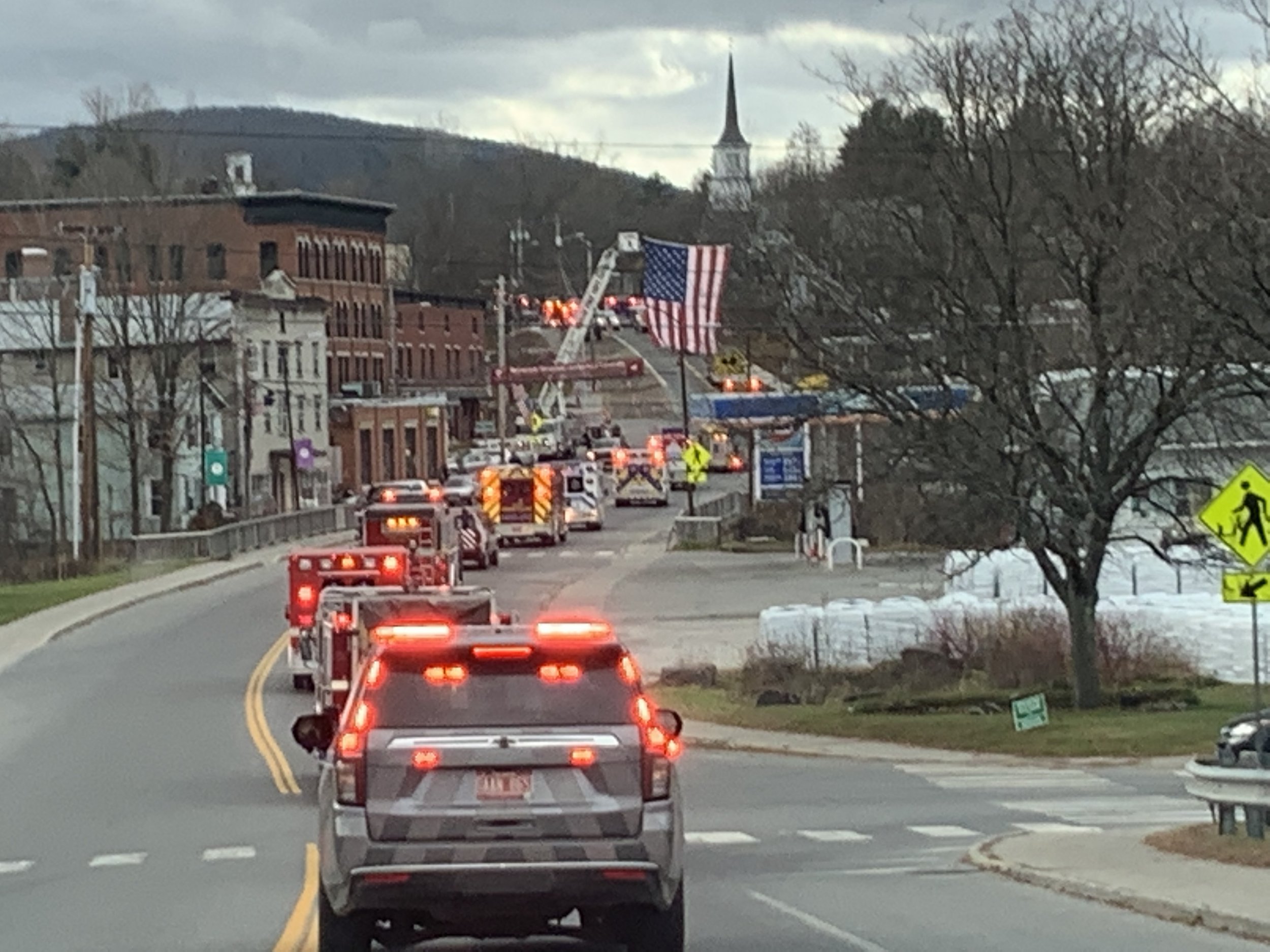  The line makes its way through downtown Northfield where the fire department flies its large flag in salute. Photo by Lisa Scagliotti 