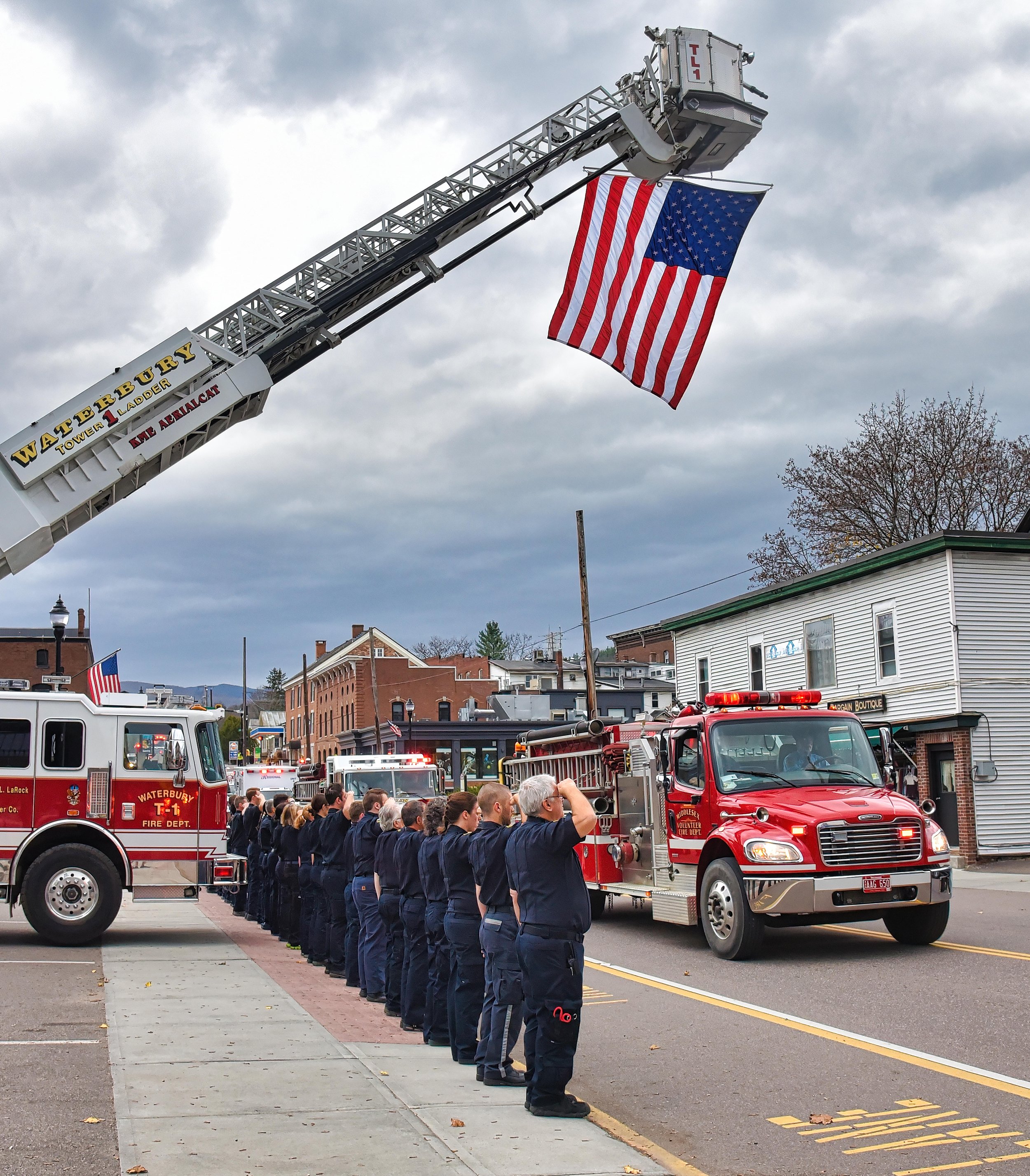  Waterbury Ambulance Service members in dress uniforms salute the passing vehicles. Photo by Gordon Miller 