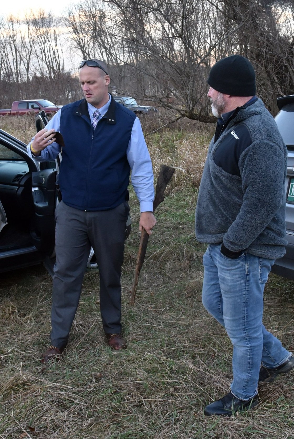  State Police Detective Trooper Mathew Nadeau  (left) checks a found item from volunteer investigator Bill McIntosh (right). Nadeau is holding the firearm found earlier in the day. Photo by Gordon Miller  