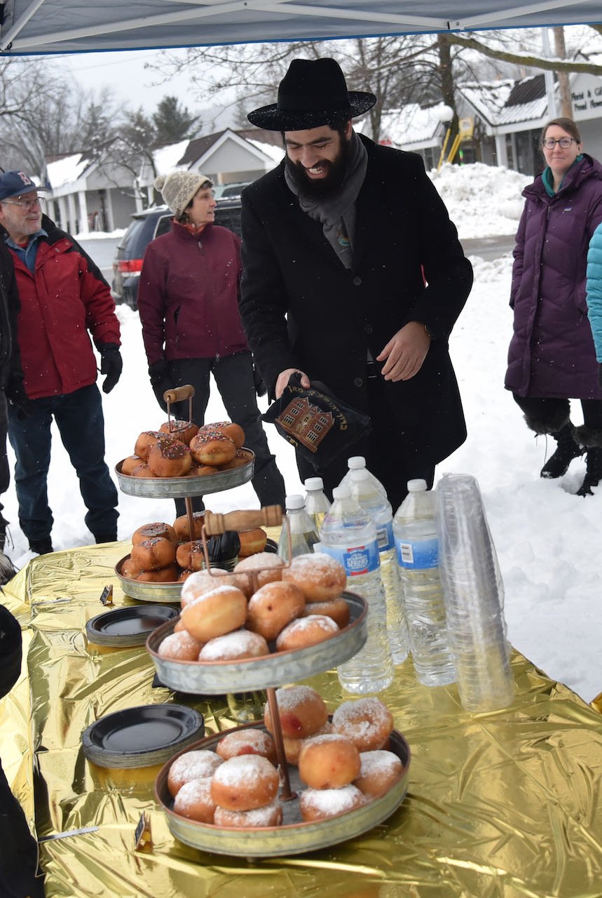   The refreshment tent offers doughnuts, latkes, and chocolate coins, to add to the Chanukah celebration. Photo by Gordon Miller  