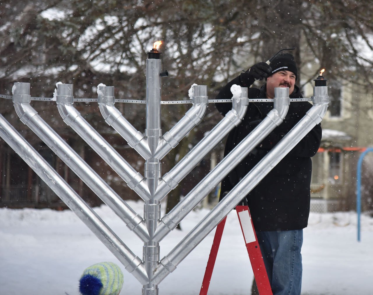   Eric Friedman lights the menorah. Another light is added each day at sunset until Dec. 25. Photo by Gordon Miller  