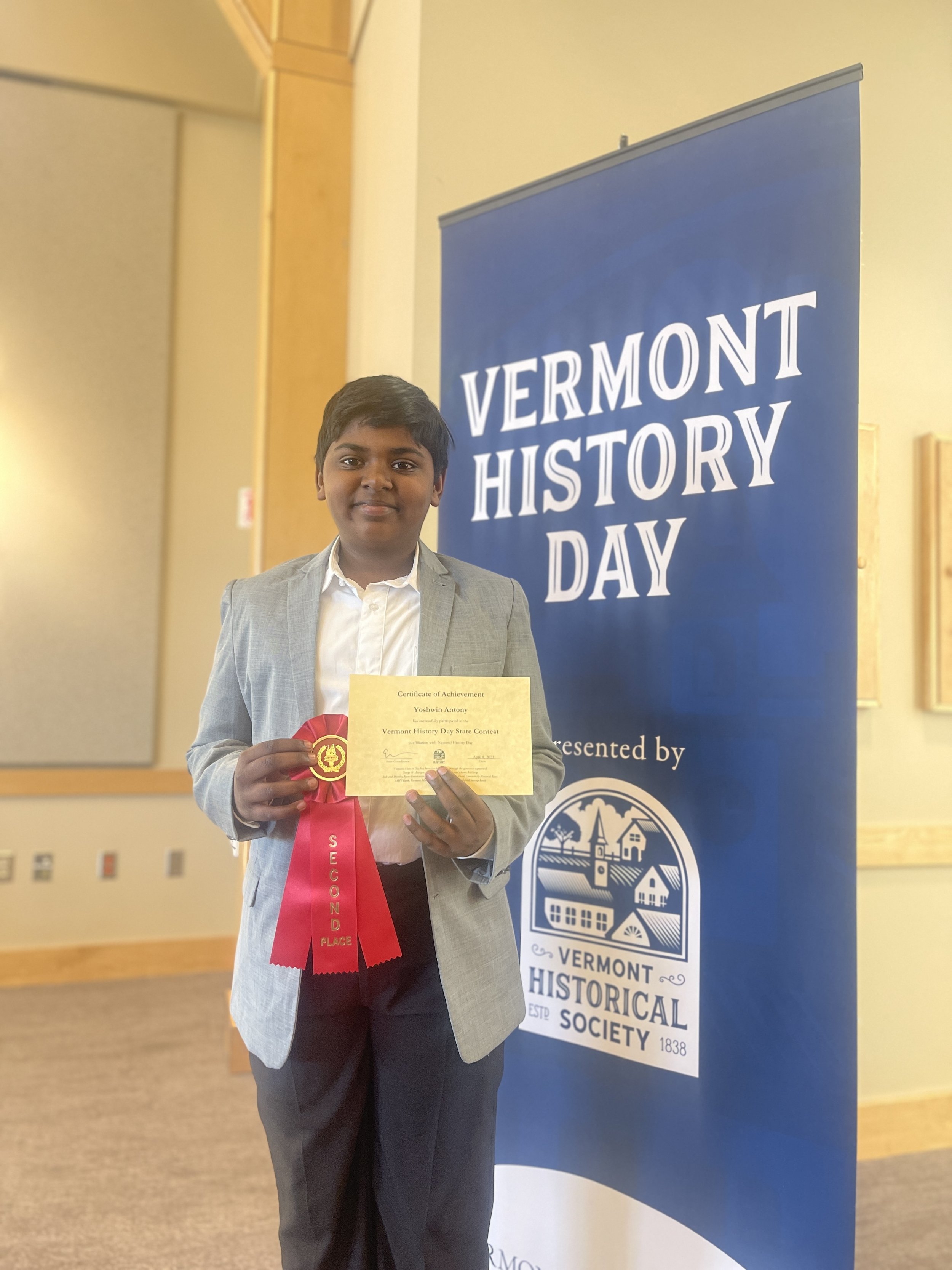   Crossett Brook Middle School sixth grader Yoshwin Antony with his second-place ribbon for "A Vermont Frontier in the Agricultural Revolution, John Deer." Photo courtesy the Vermont Historical Society.  