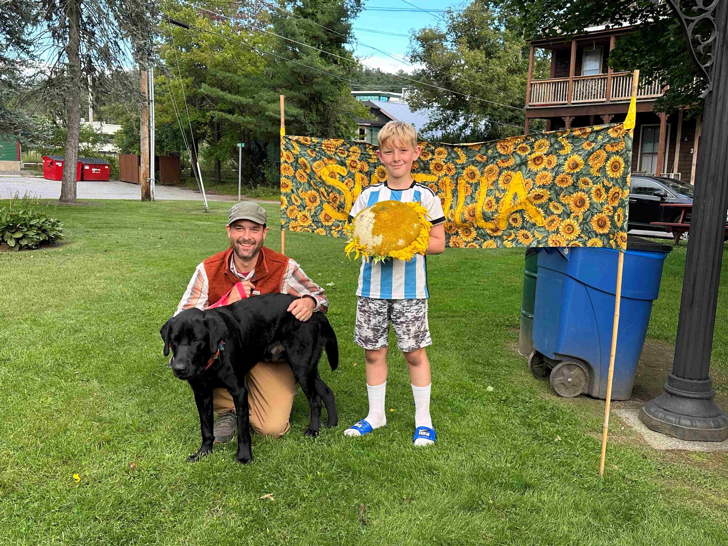  Alex Greiner (right) holds his winning flowerhead along with dad Edward and his black lab, Doug.  Photo by Lisa Scagliotti 