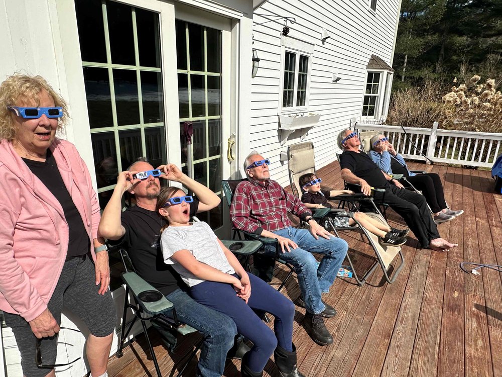   Three generations take in the eclipse from Stowe. Left to right: Virgina Bray (on her 80th birthday), Chris Bray, Evelyn Bray, Kenneth Bray, Julian Bray, John Greene, Deb Greene.&nbsp;Photo by Chelsea Greene Bray  