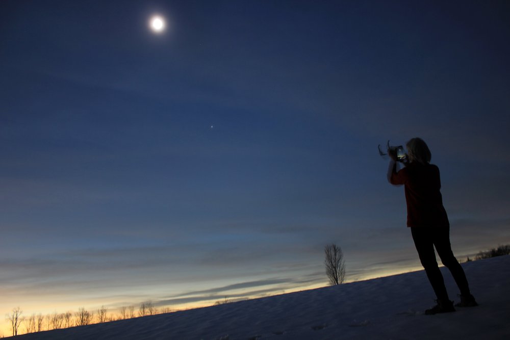   Kit Walker takes a shot of the eclipse at Sweet Meadow in Waterbury Center. Photo by Rob Hofmann  