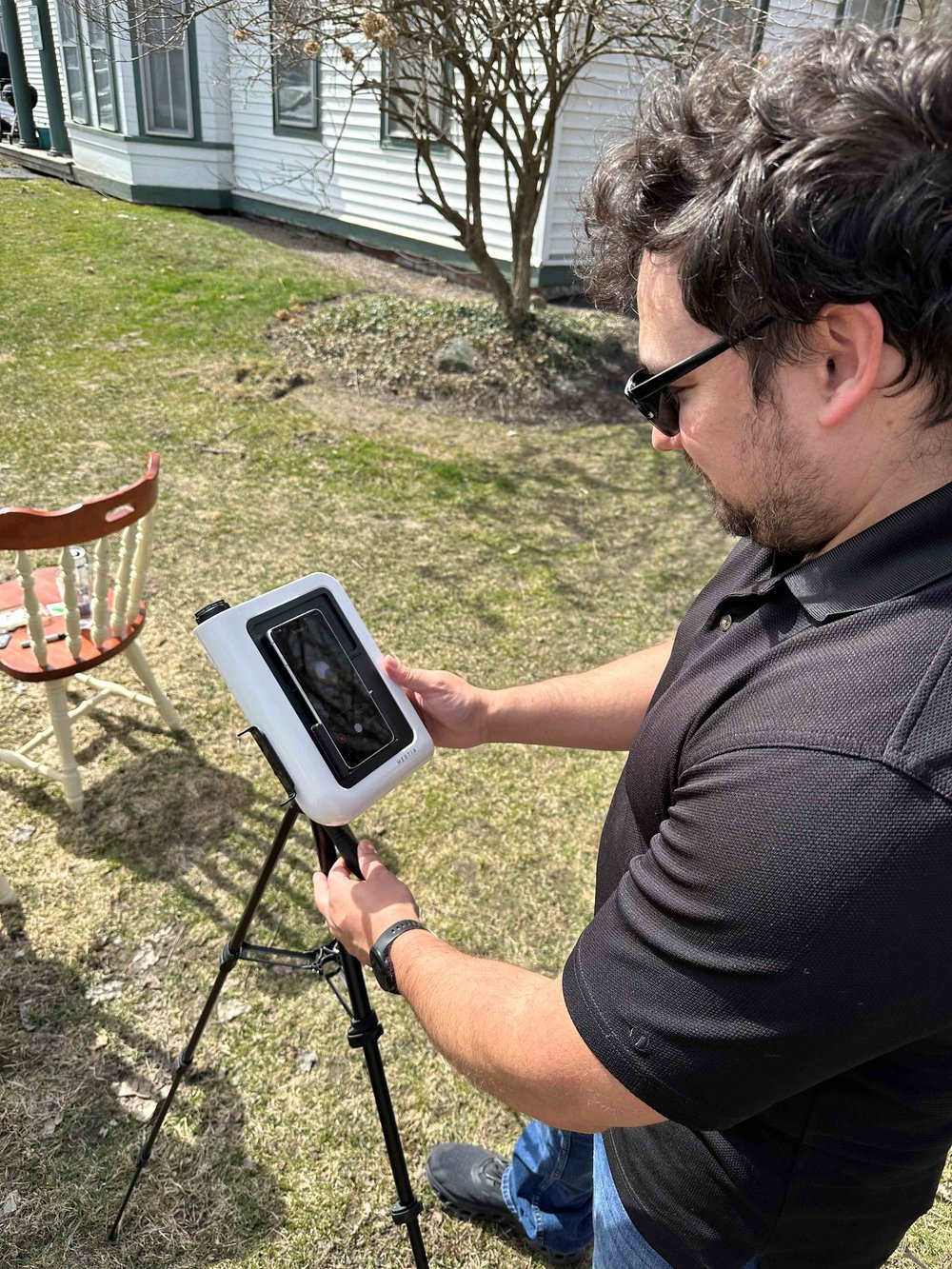   Stan Tribble uses a smartphone telescope in his yard along Main Street. Photo by Lisa Scagliotti  