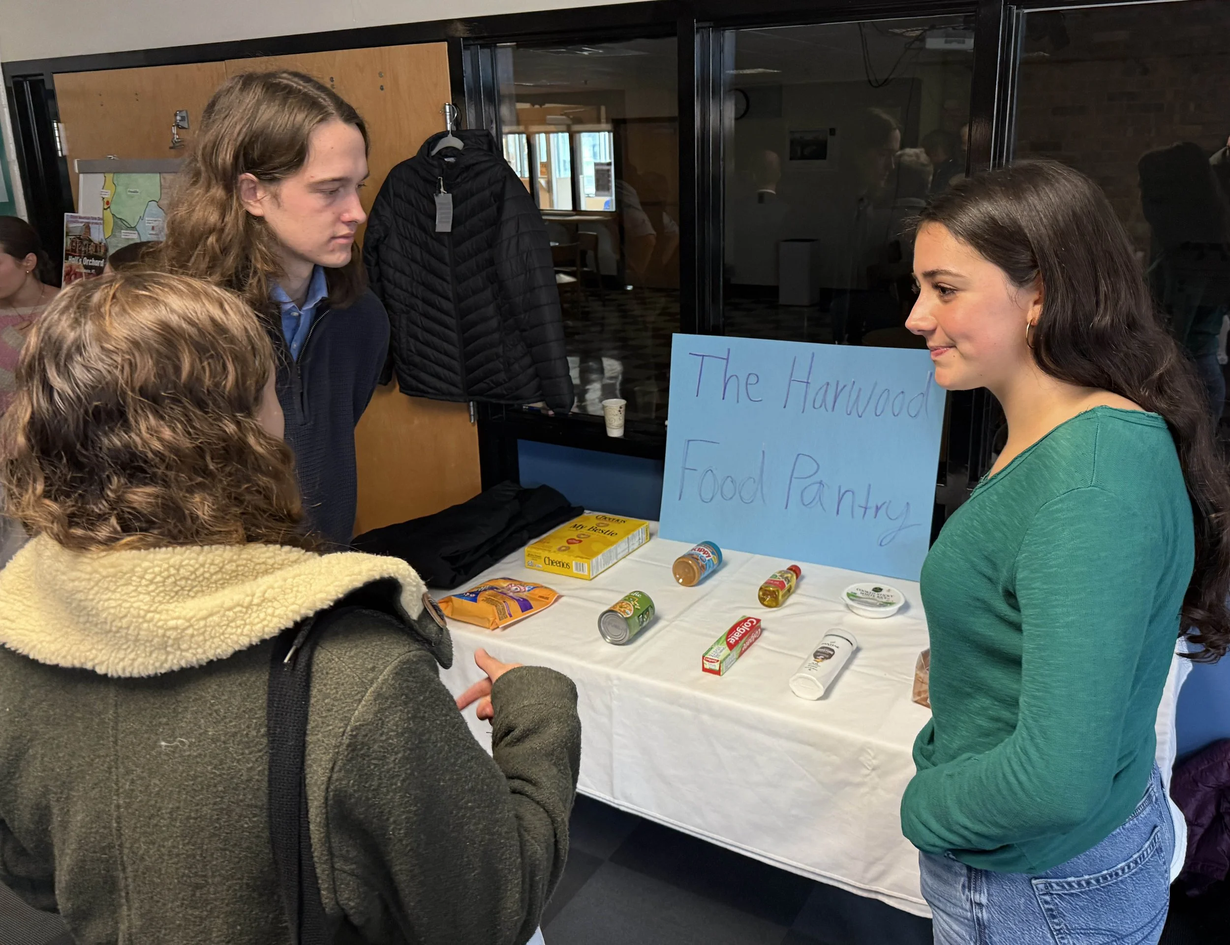   Harwood students Cashel Higgins (left) and Lessa Dreimiller (right) explain the new Harwood Food Pantry project to Gina Clithero from the Agency of Agriculture. Photo by Gordon Miller  