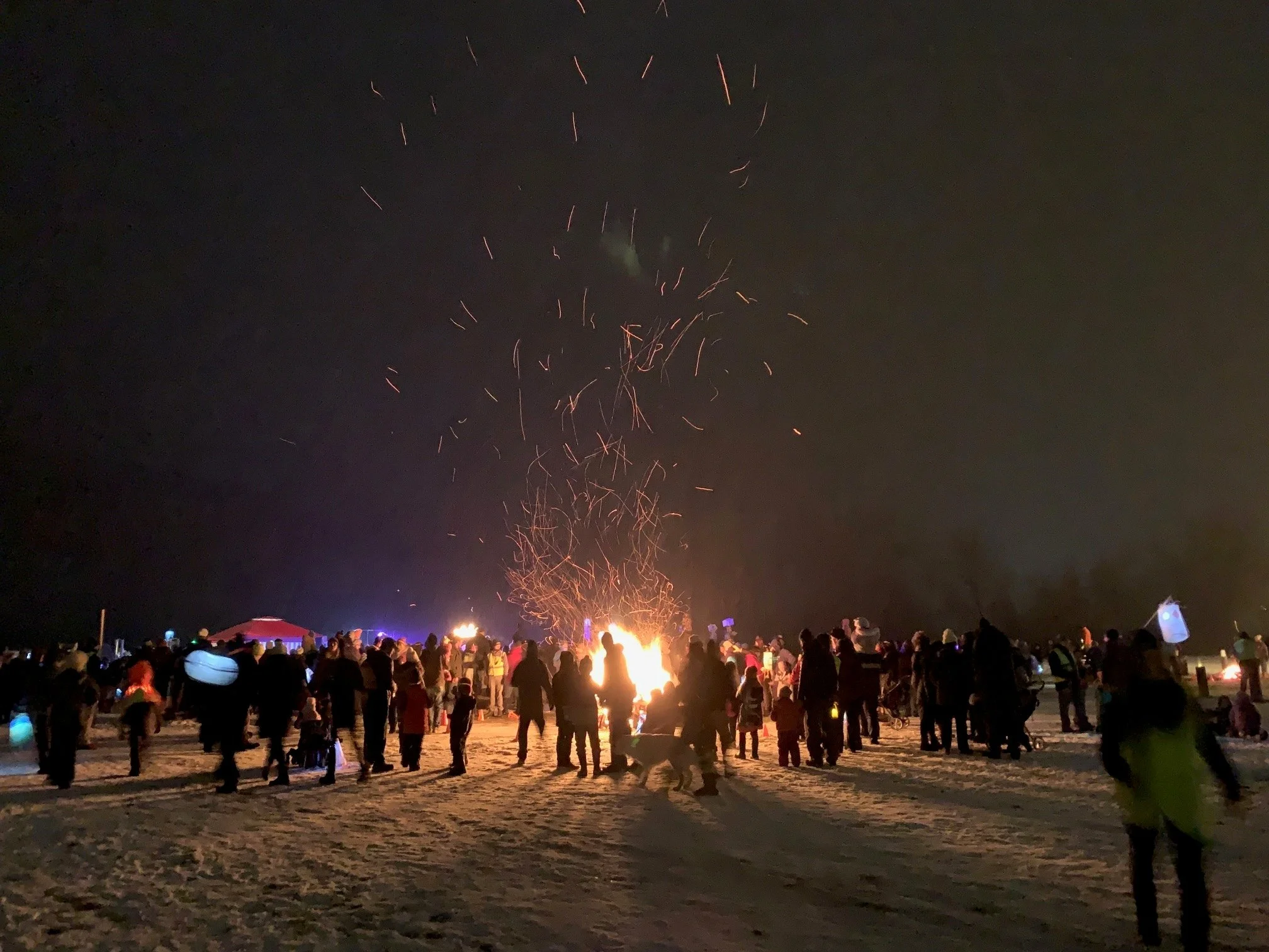   Parade-goers warm up at the bonfire at the end of the 2021 River of Light parade. Photo by Lisa Scagliotti&nbsp;       