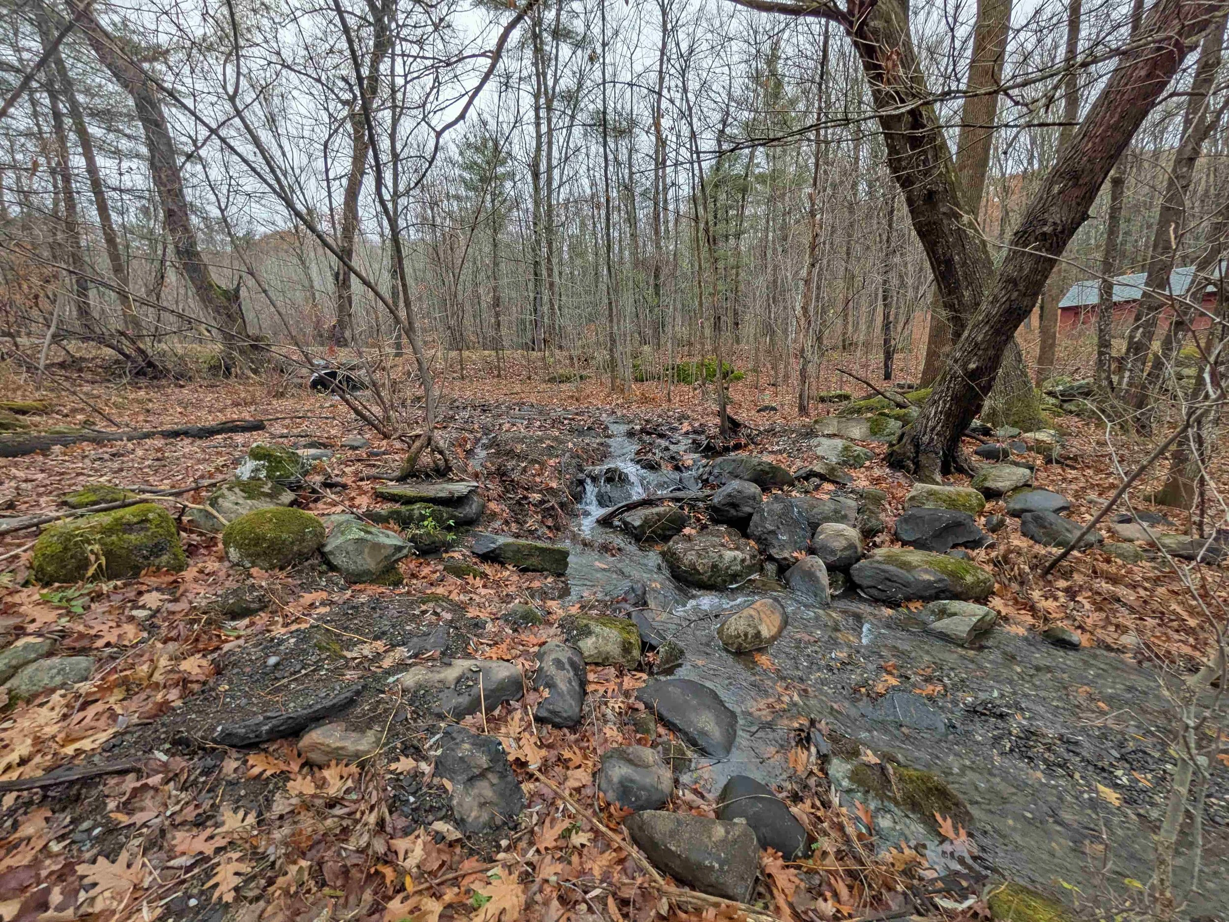   The unnamed Winooski River tributary flows freely after the stone dam is removed. New culvert is visible in background. Vt. Land Trust photo  