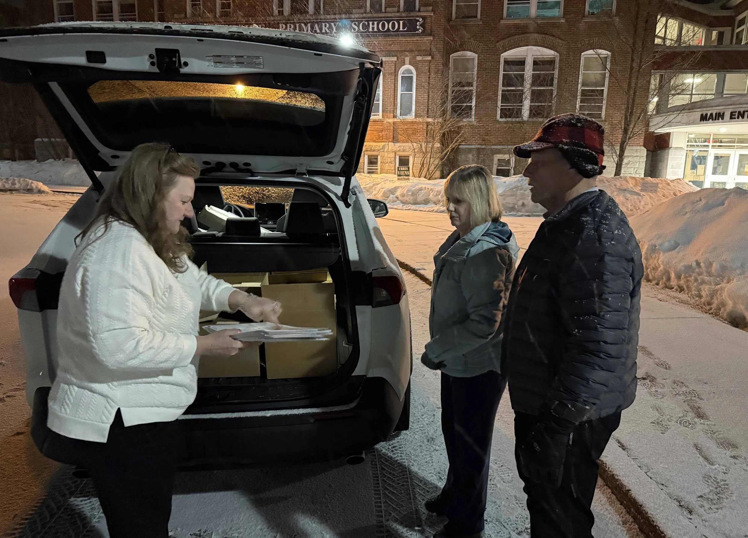   Town Clerk Beth Jones and Waterbury Select Board member Roger Clapp meet Harwood Finance Director Lisa Estler arriving at Brookside Primary School for Tuesday night's ballot count. Photo by Gordon Miller  