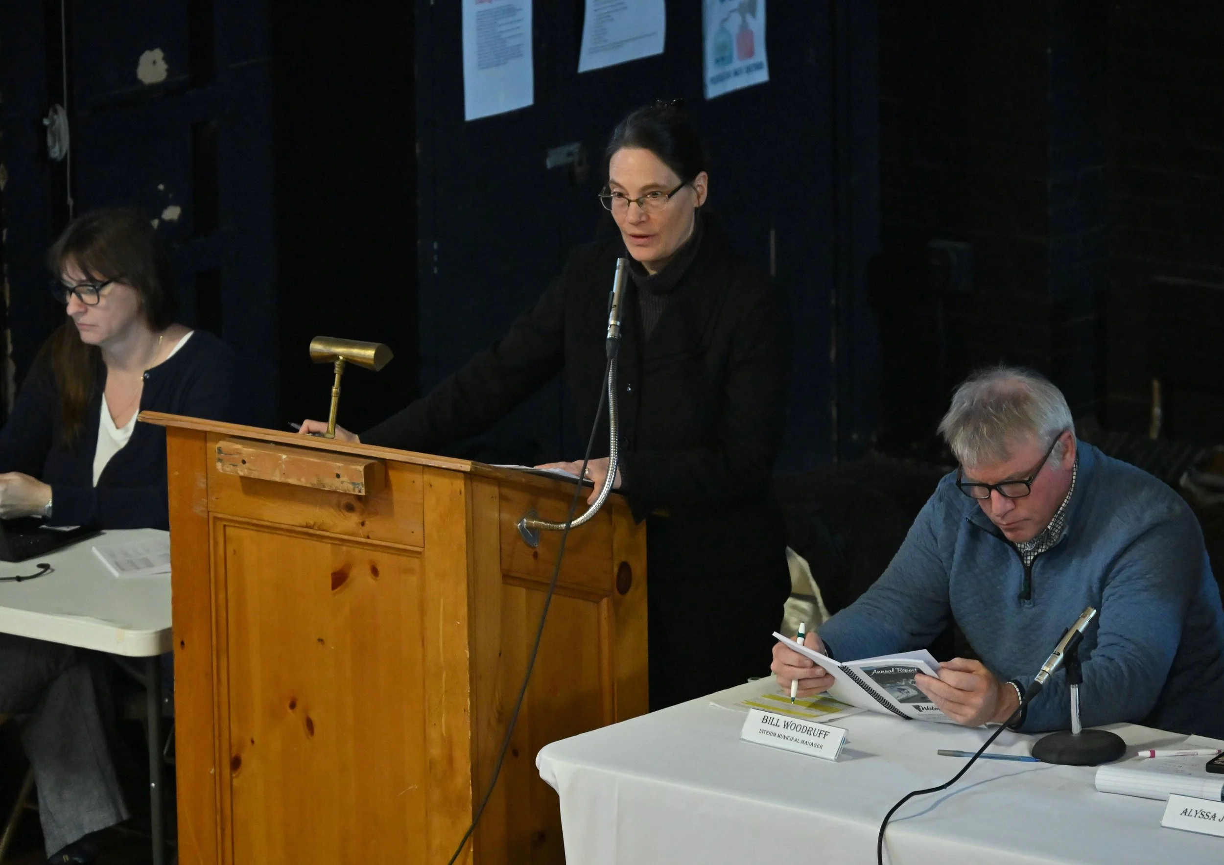   Former Town Clerk Karen Petrovic takes minutes (left) as Moderator Rebecca Ellis runs the meeting. Beside her is interim Town Manager Bill Woodruff. Photo by Gordon Miller   