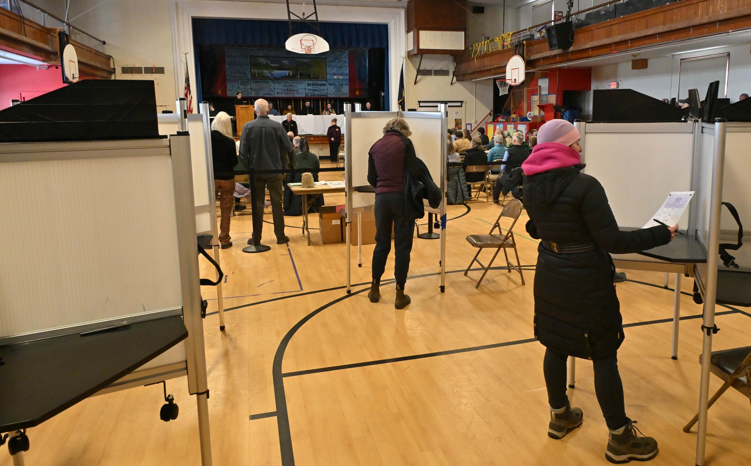   Voters mark their ballots as the meeting progresses. Photo by Gordon Miller   