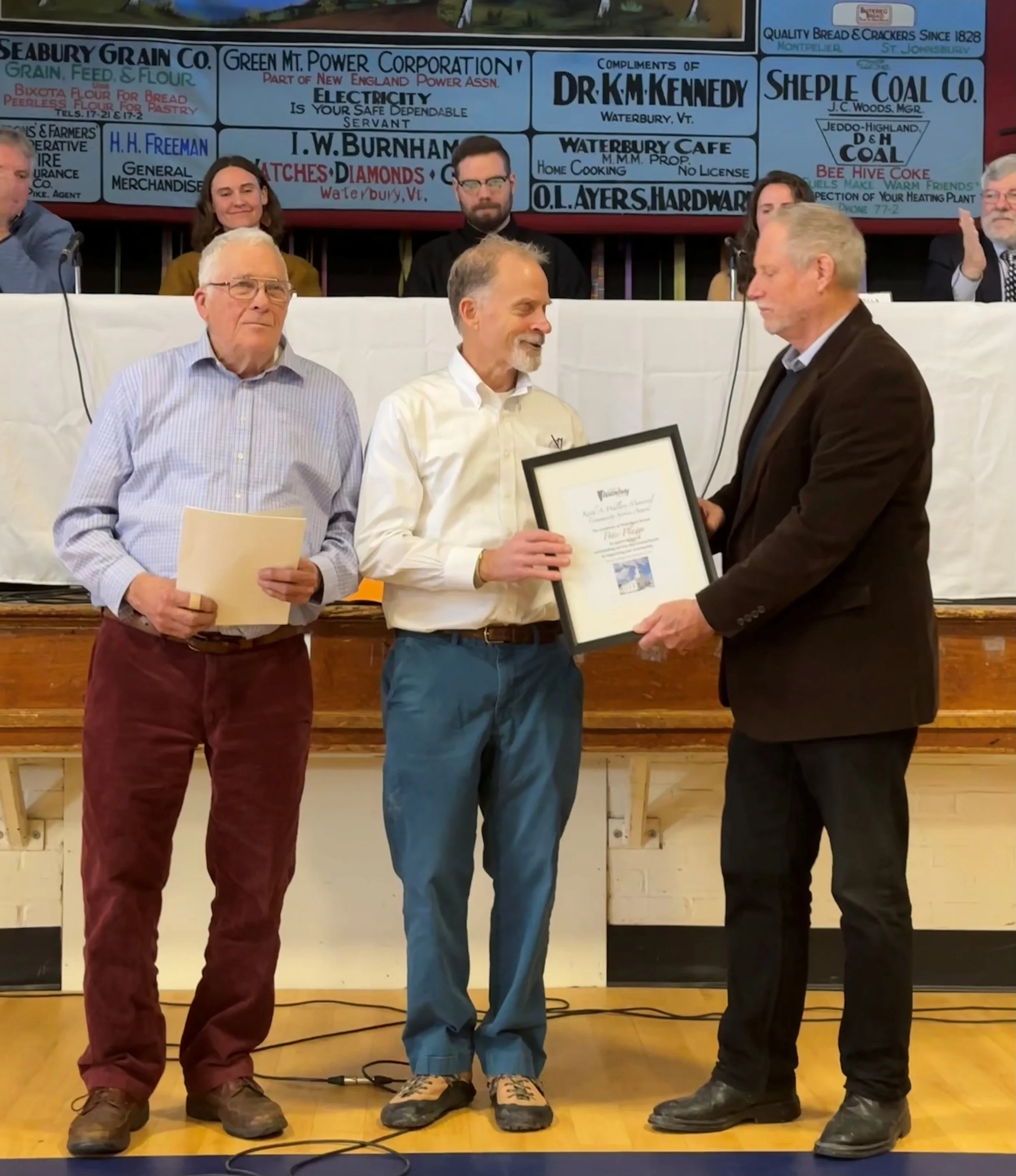   Skip Flanders (left) and Roger Clapp (right) present Rev. Peter Plagge with the Keith A. Wallace Award. Photo by Lisa Scagliotti  