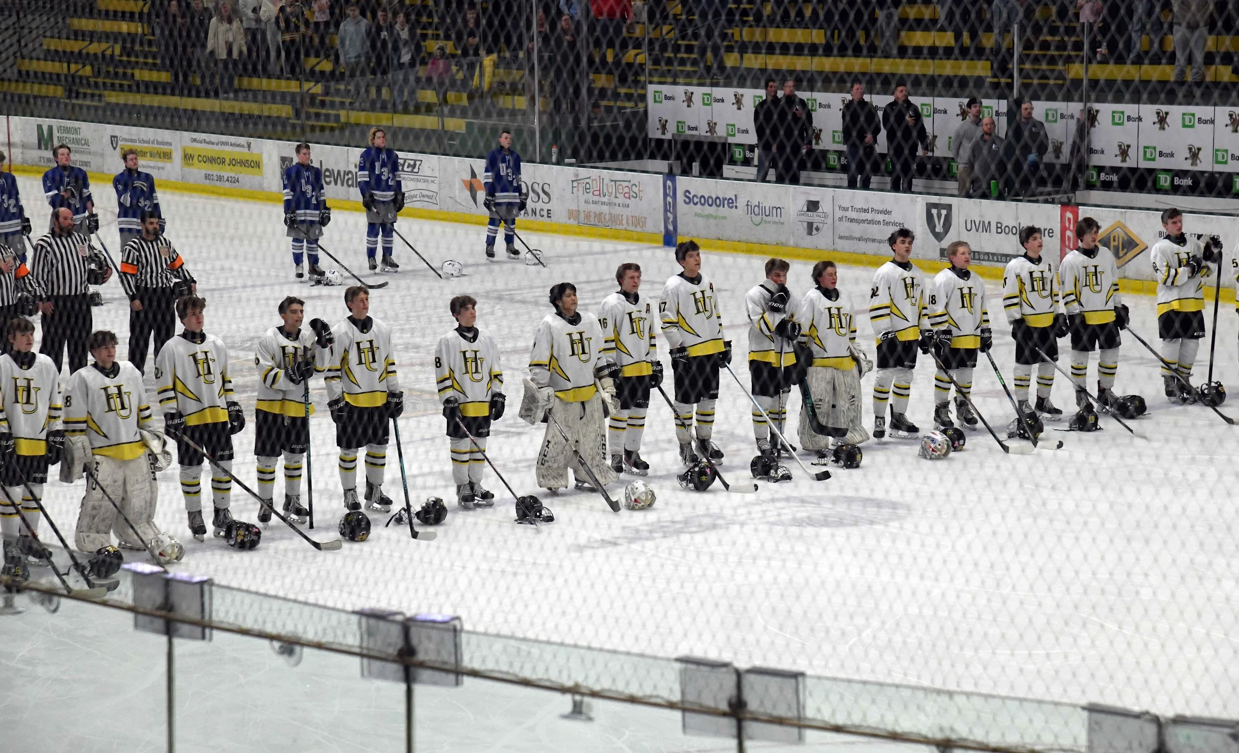   Players and refs on the ice for the national anthem.&nbsp;Photo by Gordon Miller  