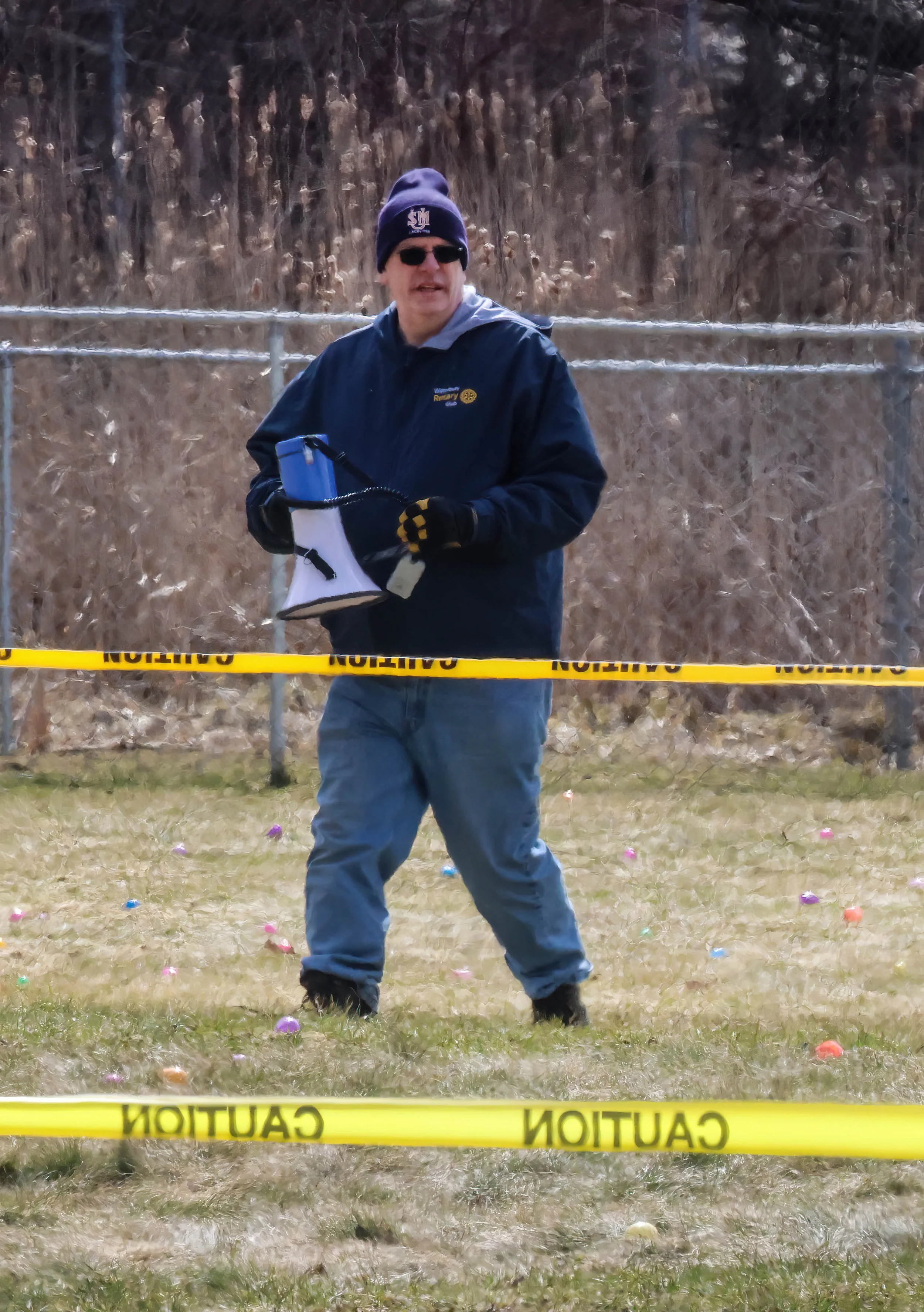   Rotarian Jeff Smith is a lead organizer for the egg hunt who signals the start using a loudspeaker. Photo by Gordon Miller  