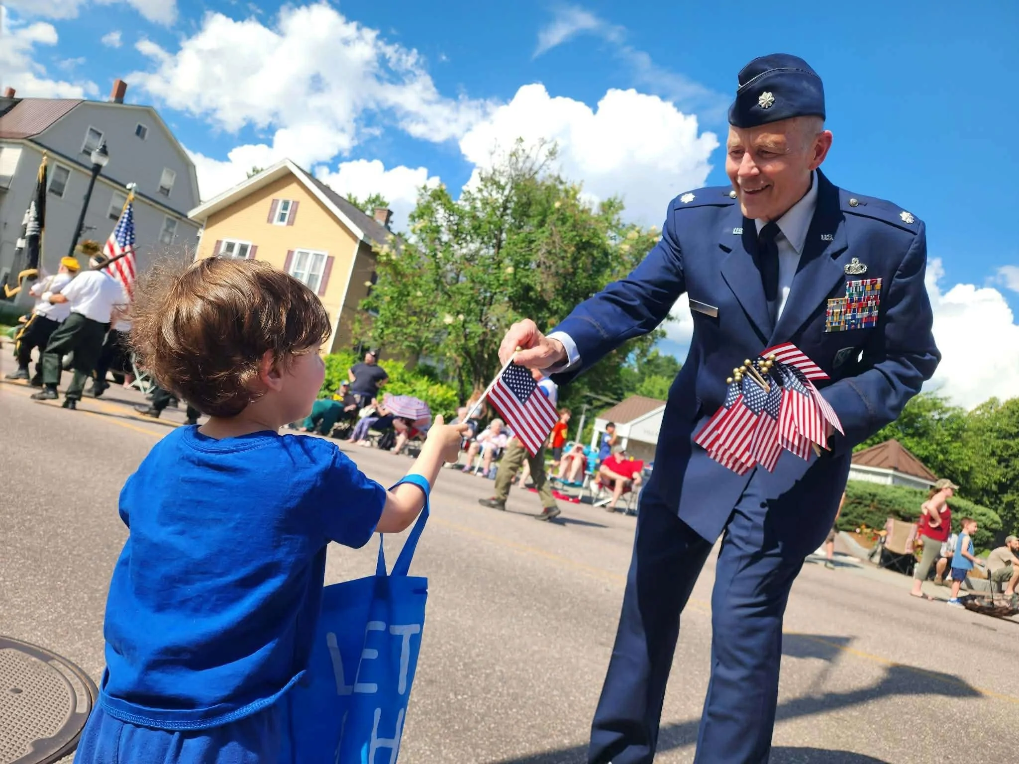 American Legion Post 59 Commander Wayne Goulet hands out mini American flags during the parade. Photo by Liz Bacon 