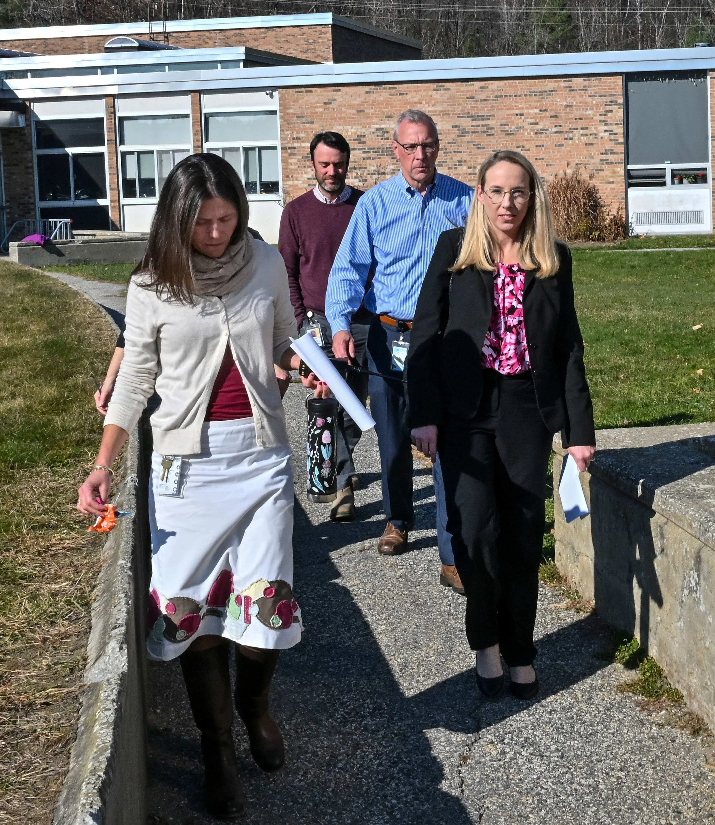  Education Secretary Zoie Saunders (right) walks with Harwood Principal Meg McDonough (left) and Superintendent Mike Leichliter from the middle school to the high school for her two talks with students on Thursday. Photo by Gordon Miller  