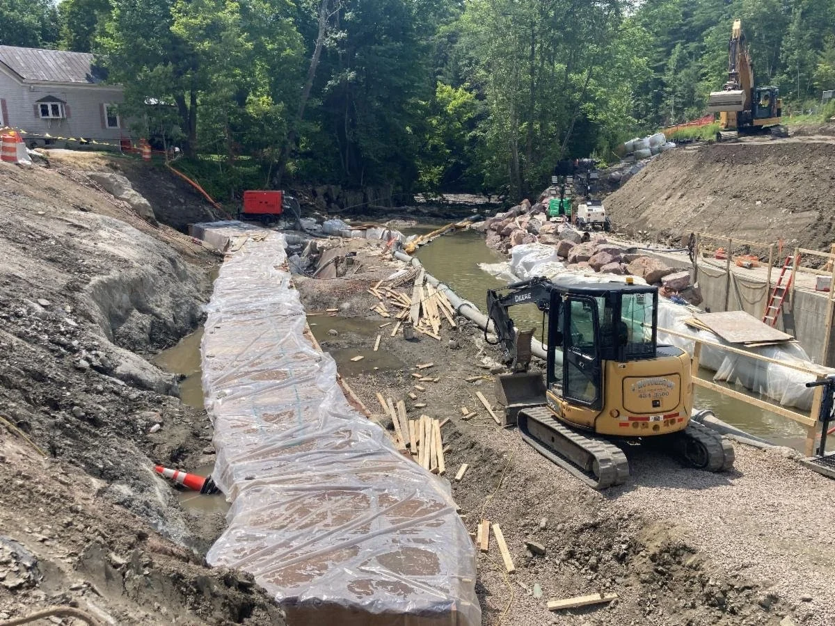  In this VTrans photo shared on Aug. 1, the cast-in-place concrete footing is being kept wet during the cure period and an excavator is building the crane pad for the 450-ton crane.  
