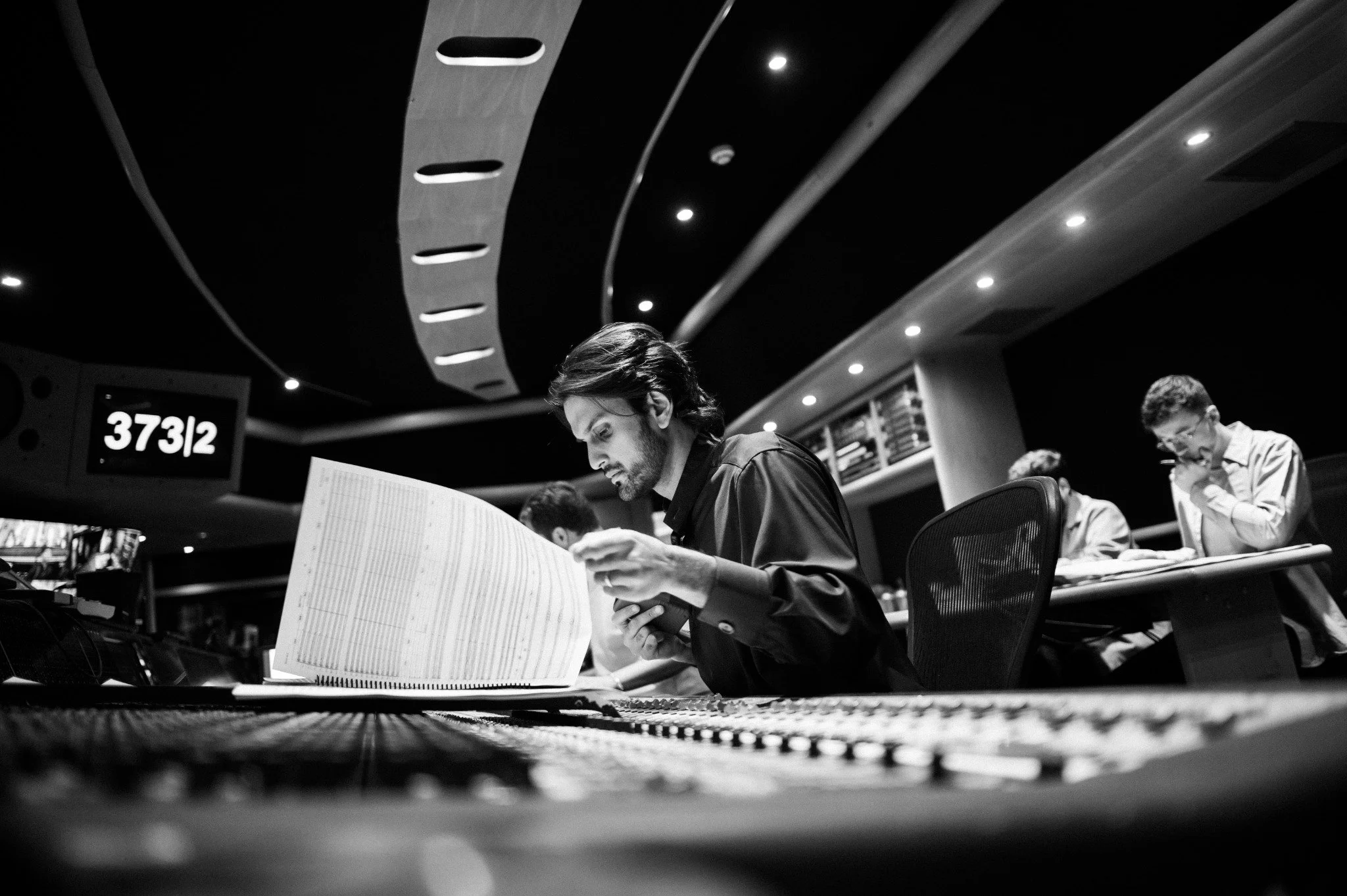 Rushil Ranjan reviewing an orchestral score at the mixing desk at AIR Studios, London.