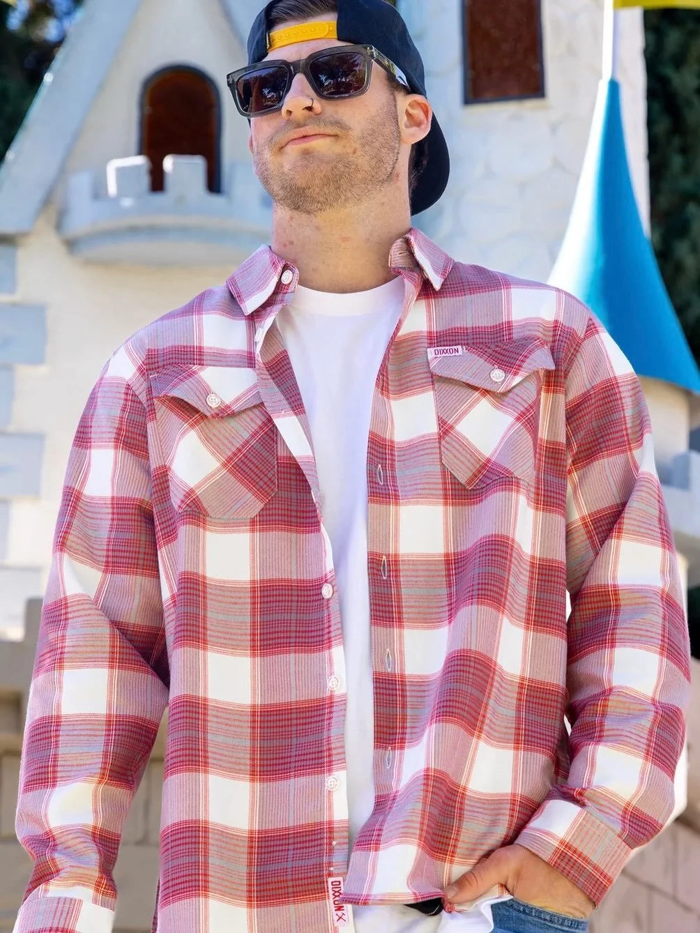 Classic, confident, and just a little unhinged in the best way, The Happy Land Dixxon Flannel brings laid back swagger to a timeless staple. Finished in a clean red, white, and gray plaid pattern, this flannel delivers everyday comfort with an unmist