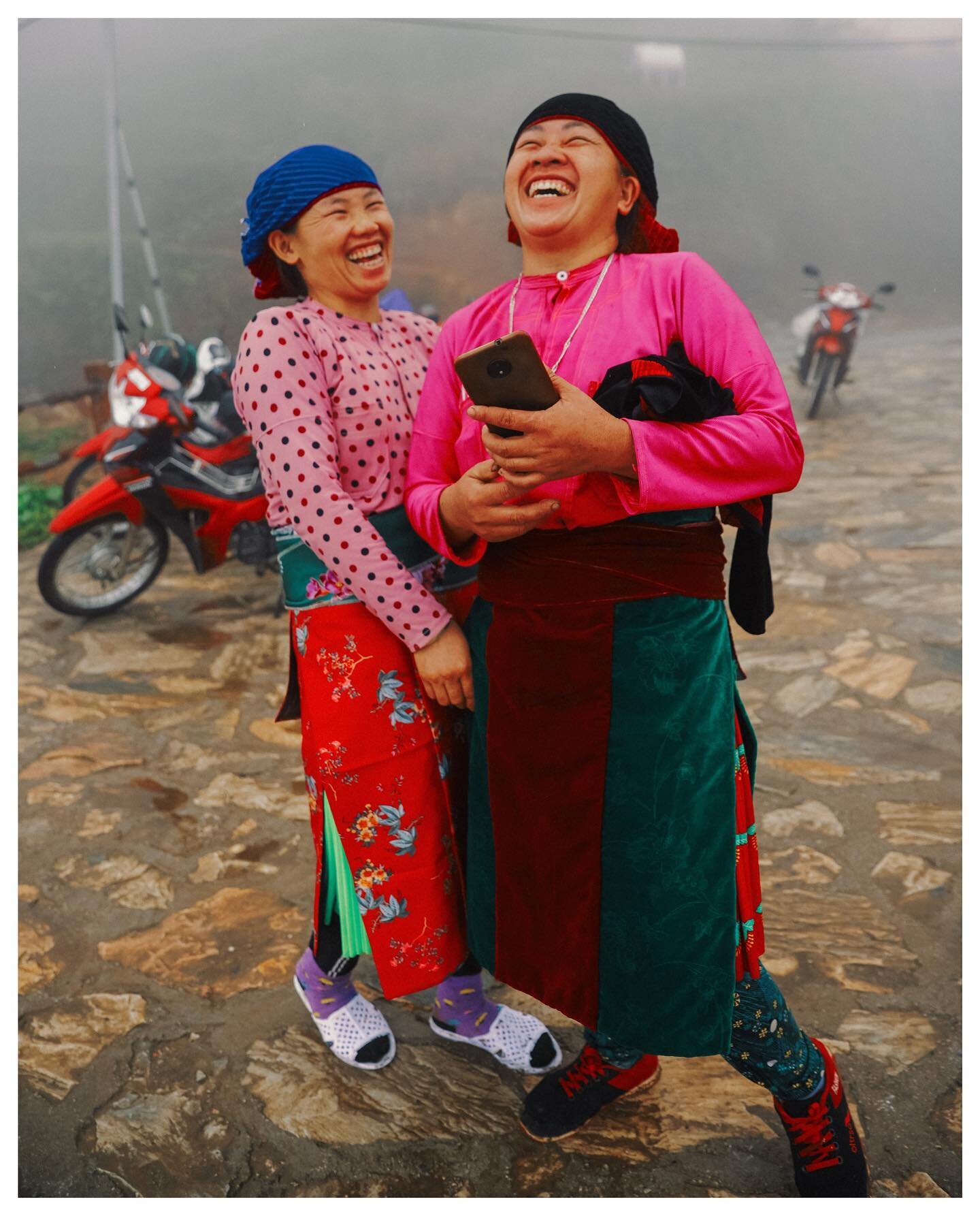 Two local women crack up while making a Tik Tok, early morning on a mountaintop near the Chinese border