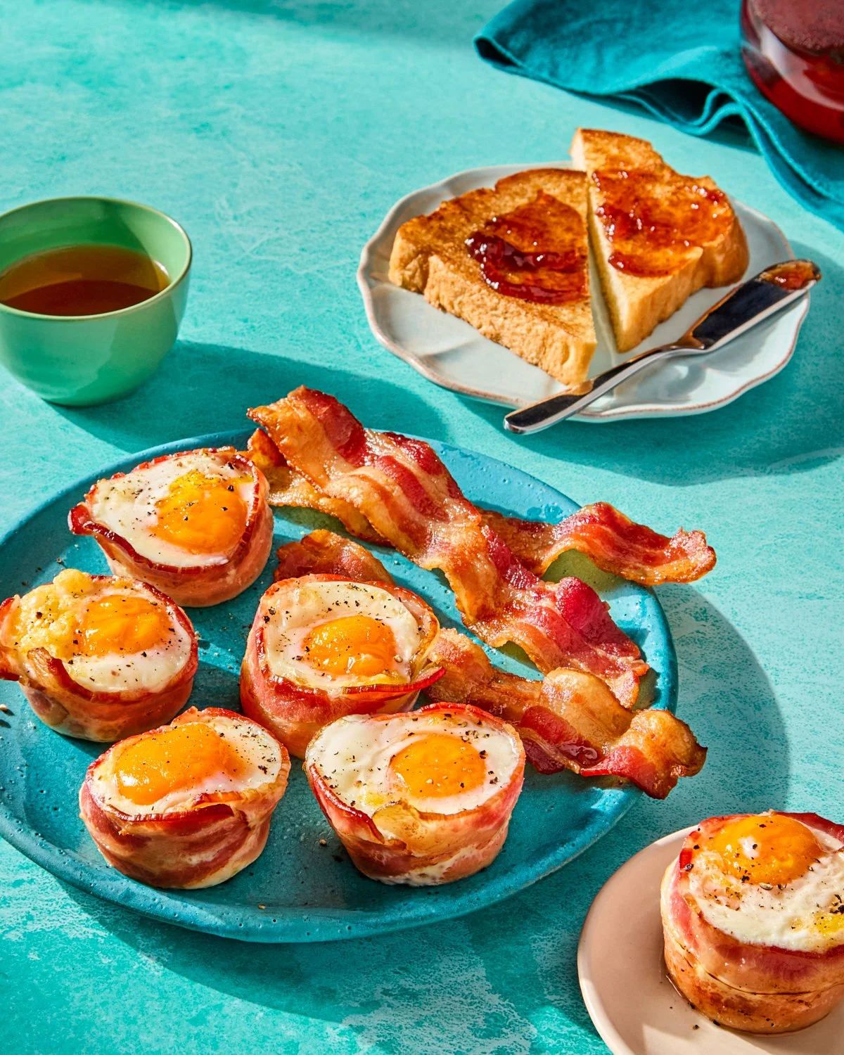 Bacon egg cups styled on a colorful breakfast set for National Pork Board recipe photography.